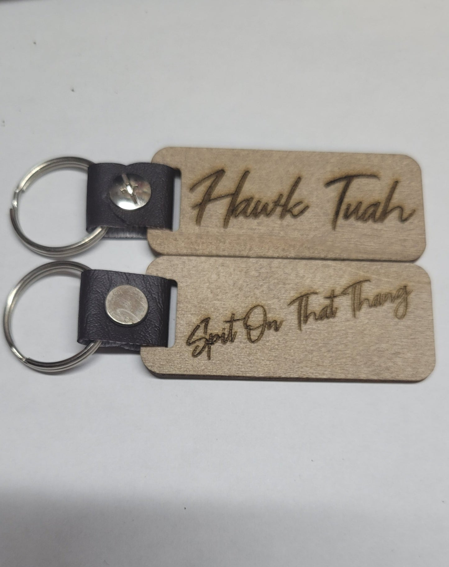 This Laser Engraved wood key chain sports the latest phrase.... Hawk Tuah. This on the front and Spit on That Thang on the back. For a fun novelty gift.... a must have