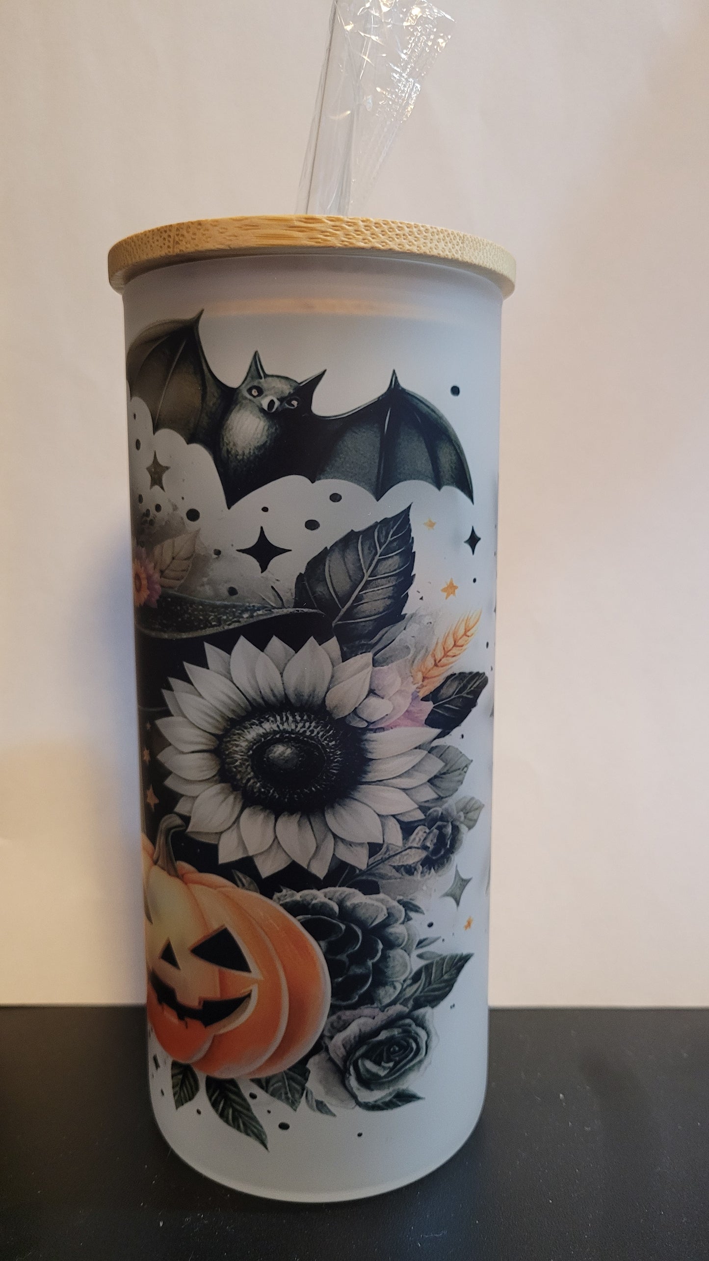 Not all ghosts are scary. Take this adorable Sunflower Ghost wearing a witch hat with a bat overhead and a carved pumpkin in the foreground. This image is sublimated onto a glass can tumbler and comes with a straw and bamboo lid.