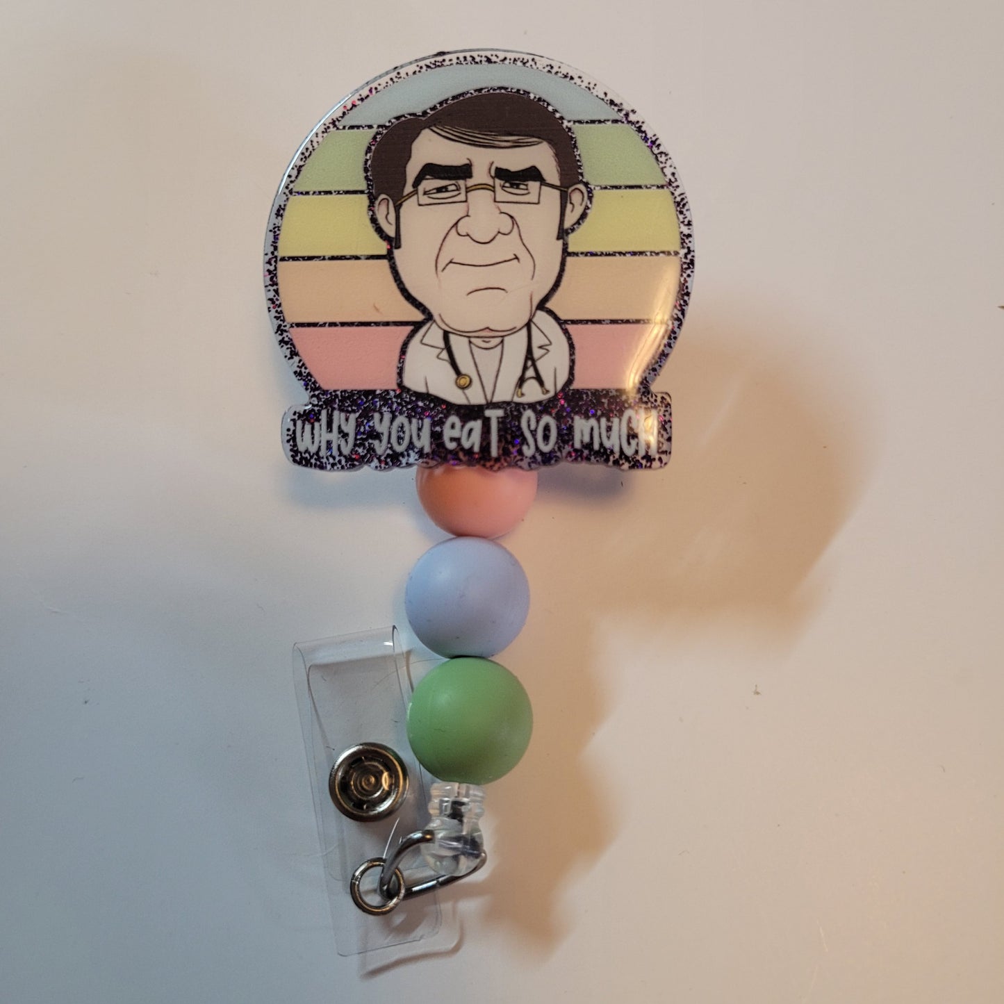 Badge holder with cartoon character and colorful beads on a plain background