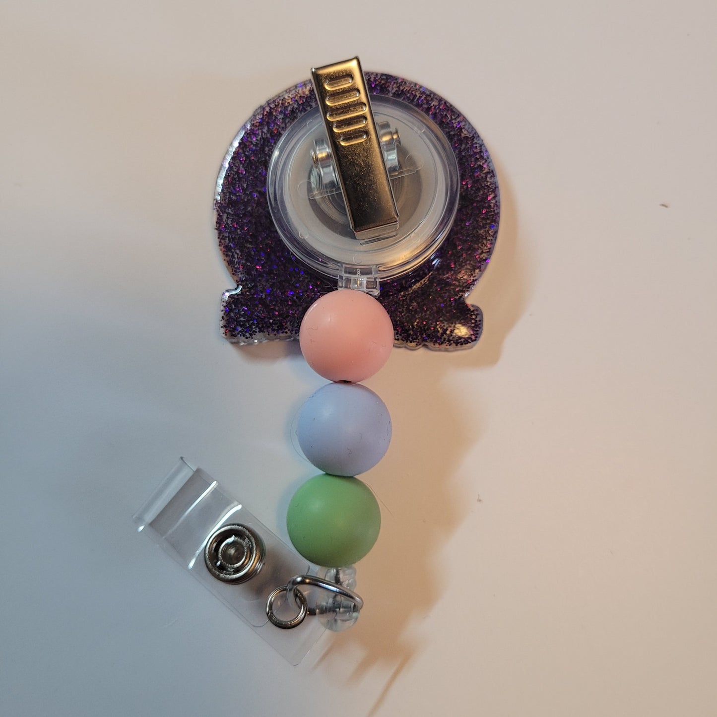 Retractable badge holder with colorful beads on a white background