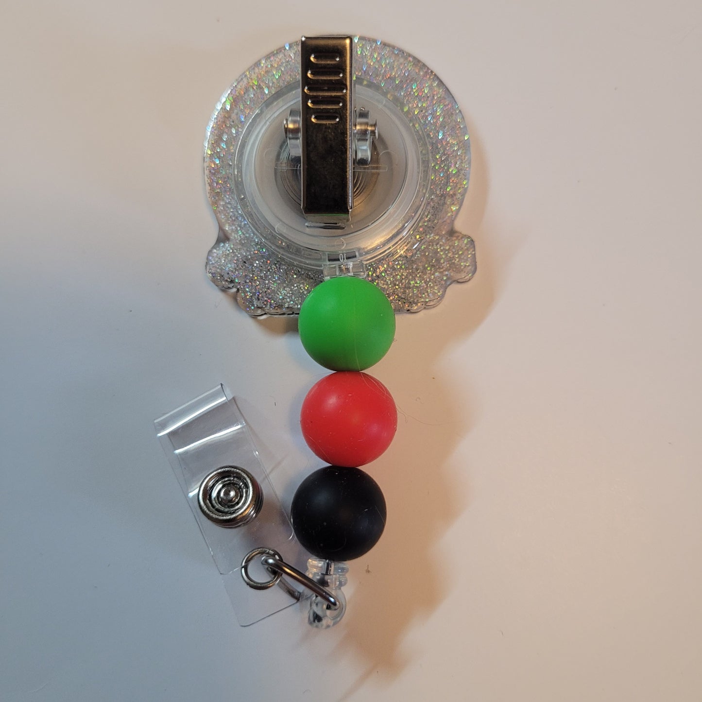 Retractable badge holder with colorful beads on a white background