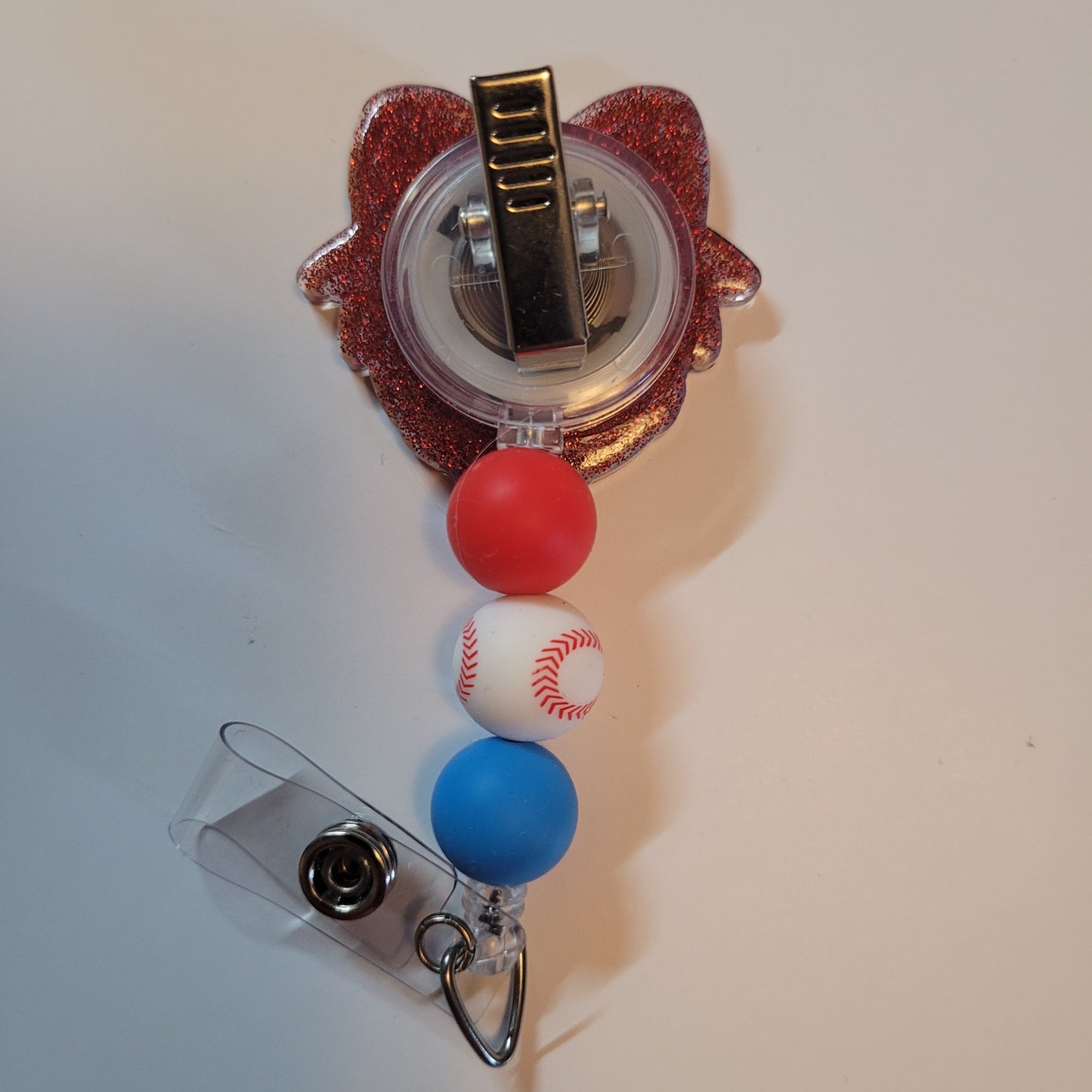 Decorative badge holder with red, white, and blue balls on a beige background