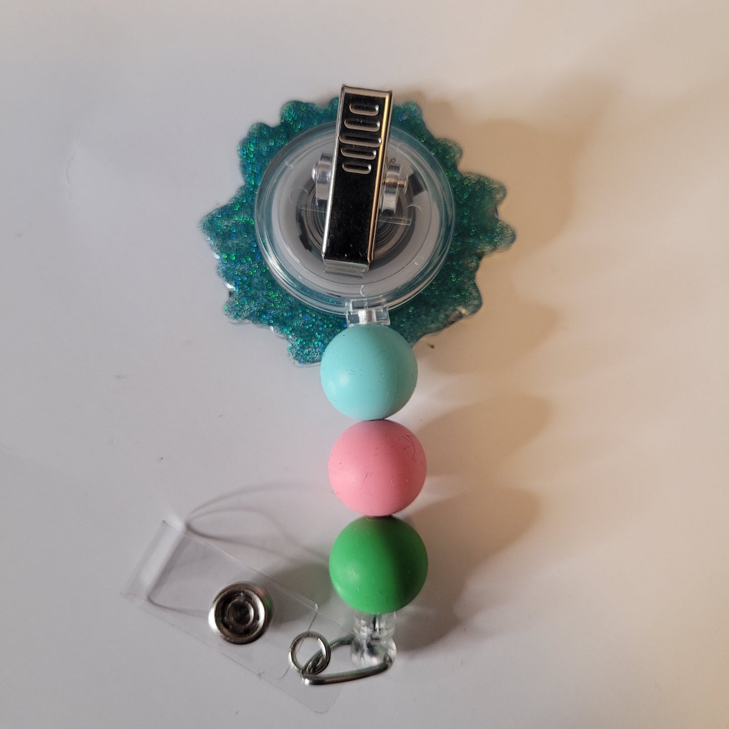 Retractable badge holder with colorful beads on a white background