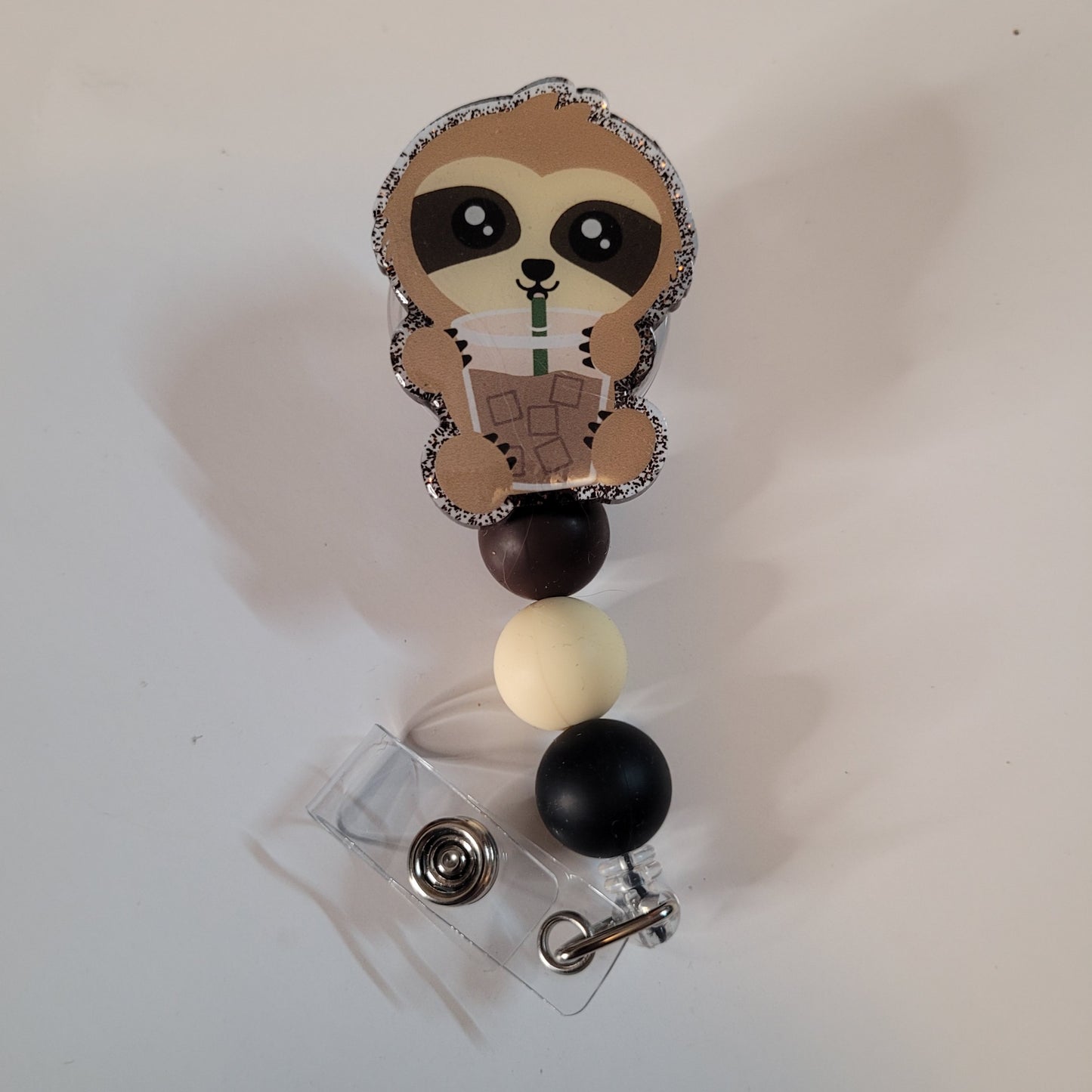 Sloth-themed badge holder with colorful beads on a white background