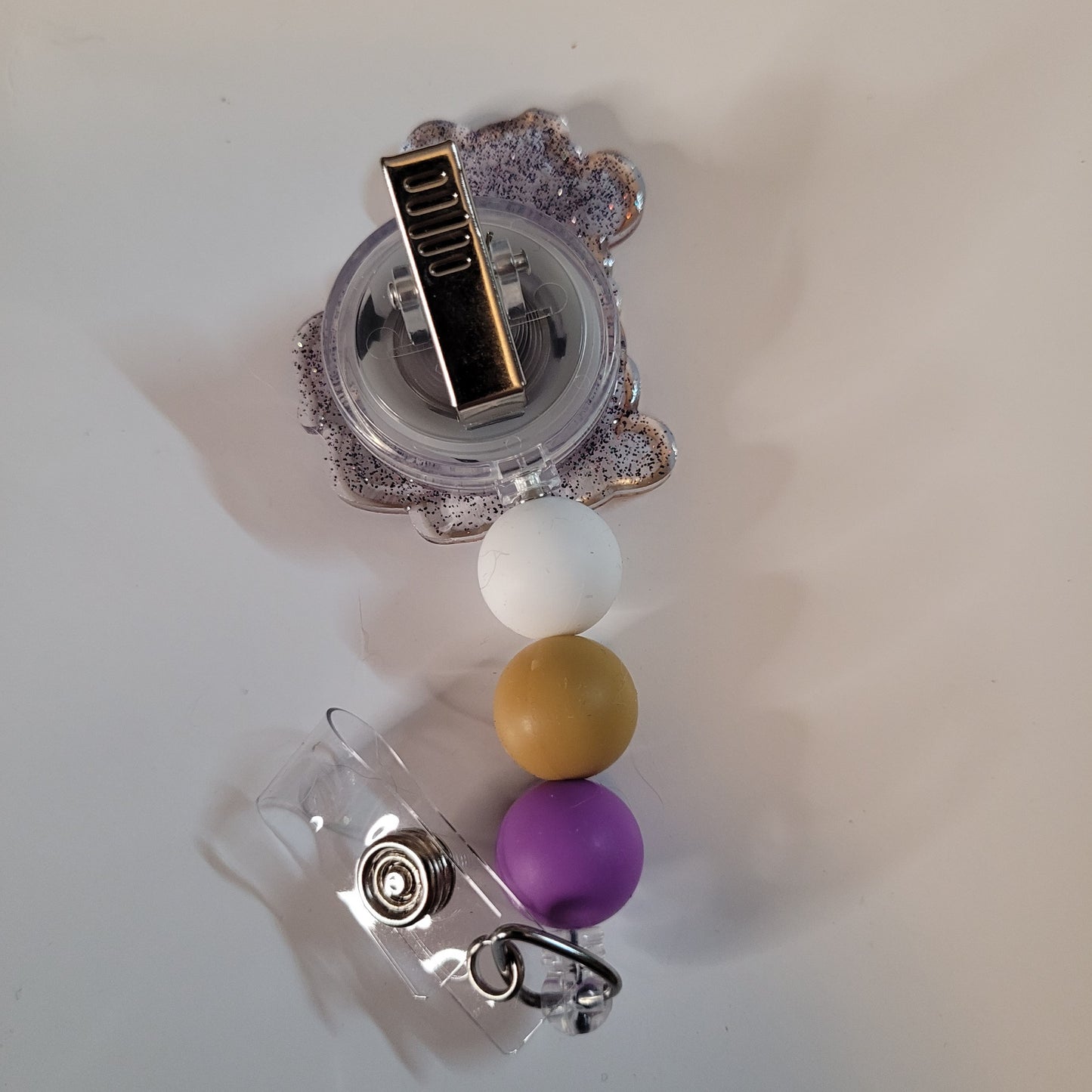 Decorative badge holder with colorful beads and a clear holder on a light background