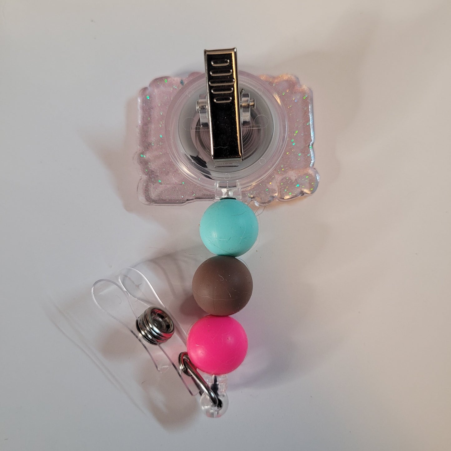 Clear badge holder with colorful beads on a white background