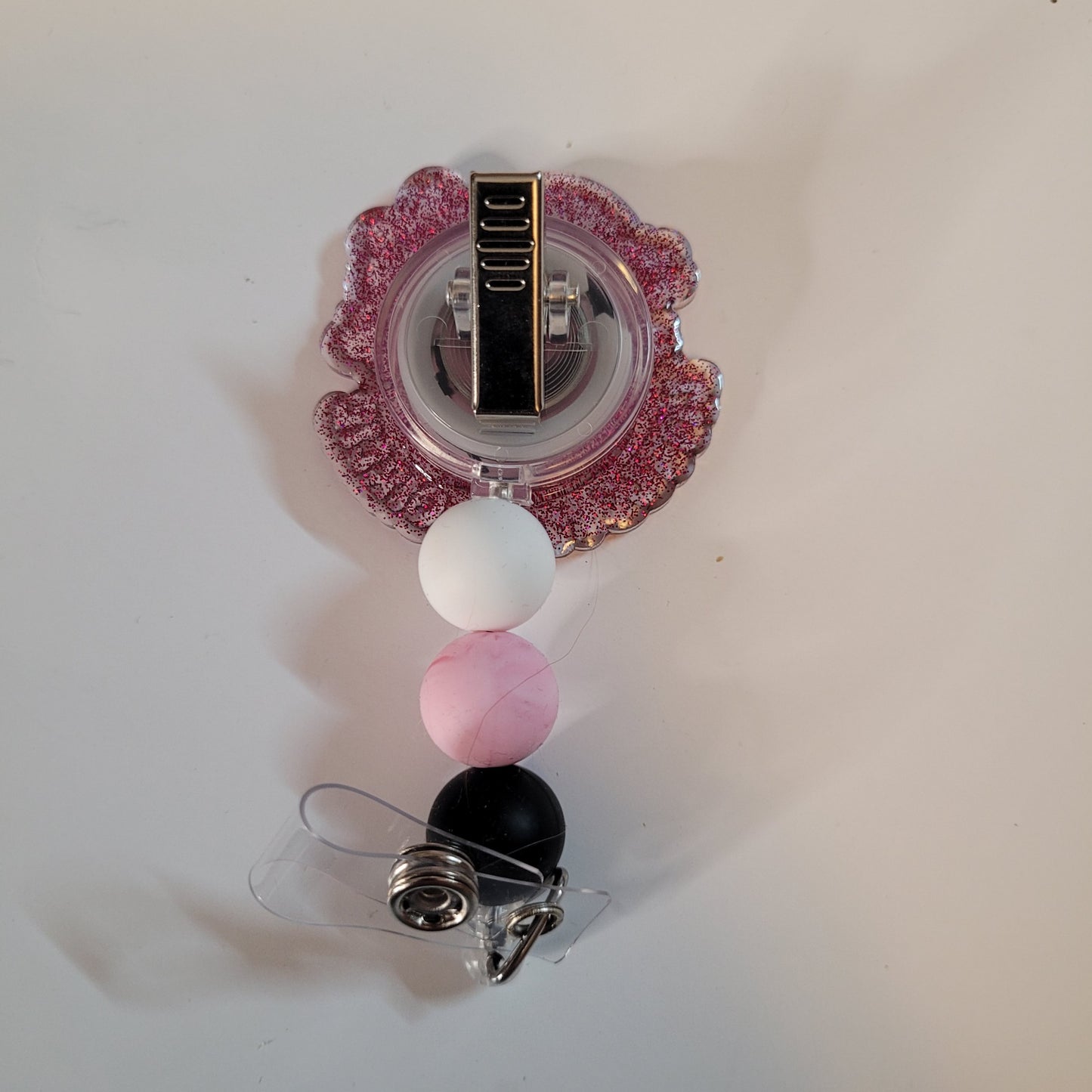 Decorative badge holder with pink, white, and black beads on a white background