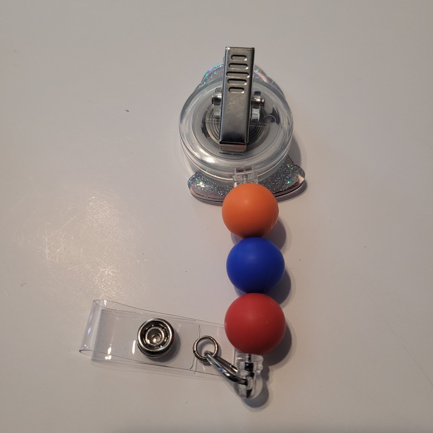 Retractable badge holder with colorful beads on a white background