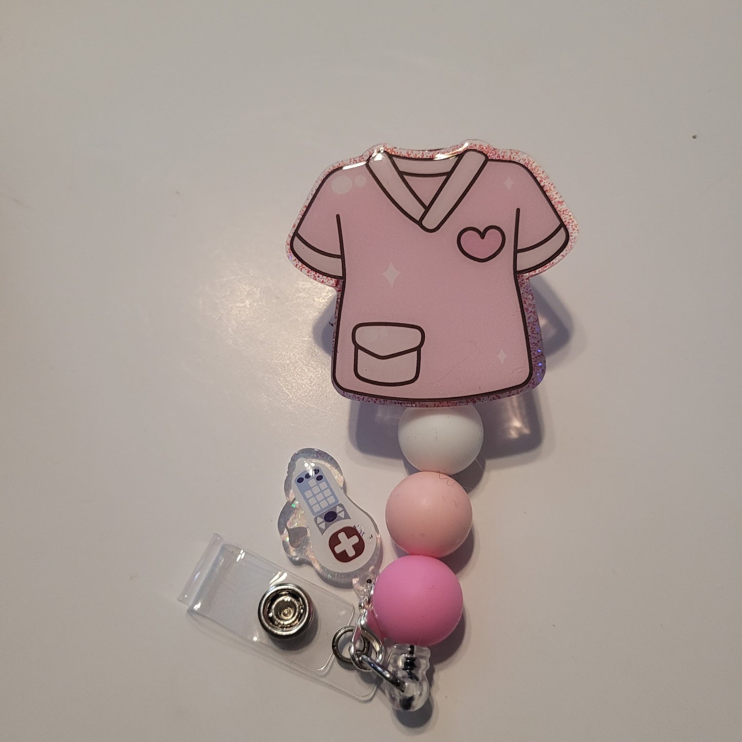 Pink badge reel with a heart design on a white background