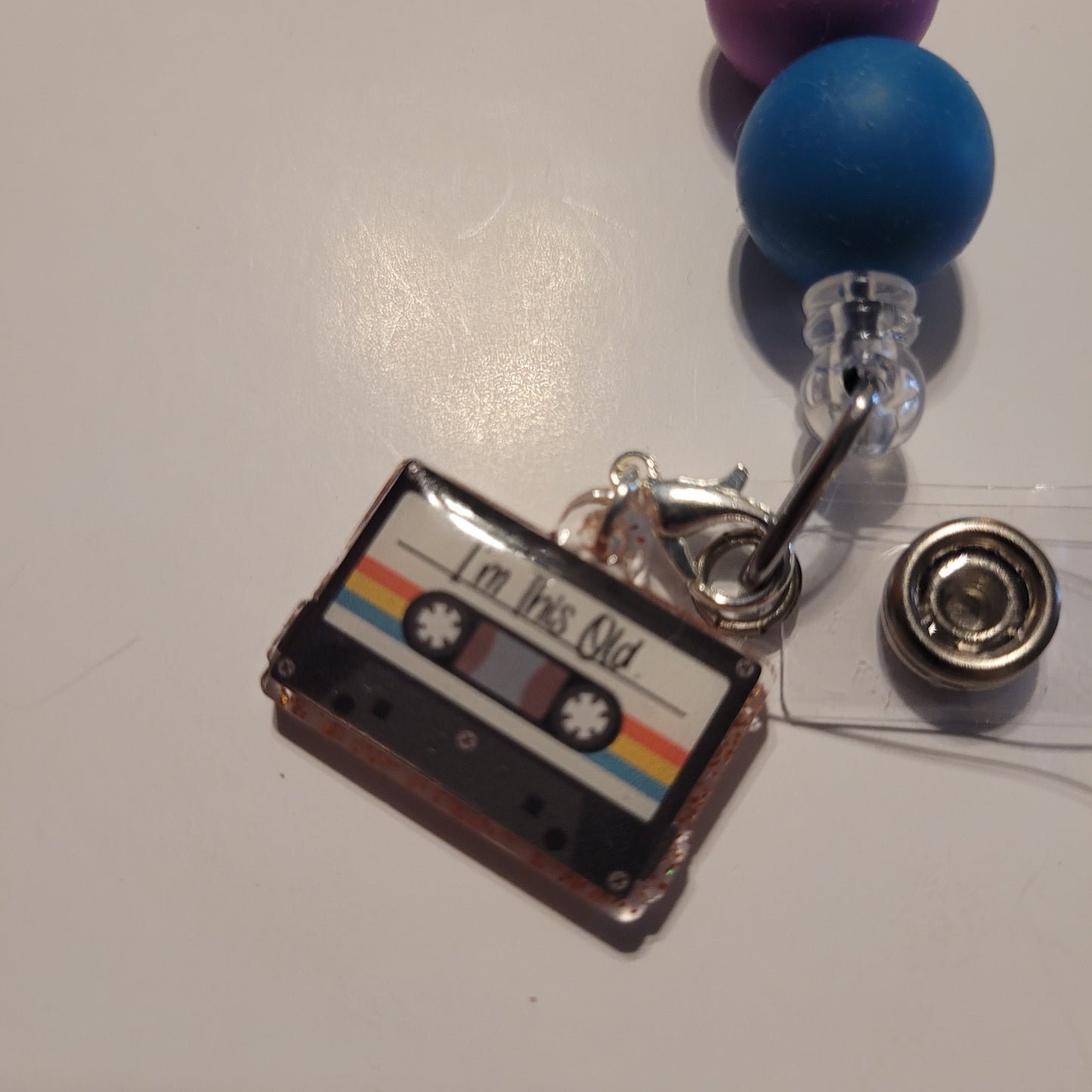 Cassette tape charm on a badge reel with colorful beads