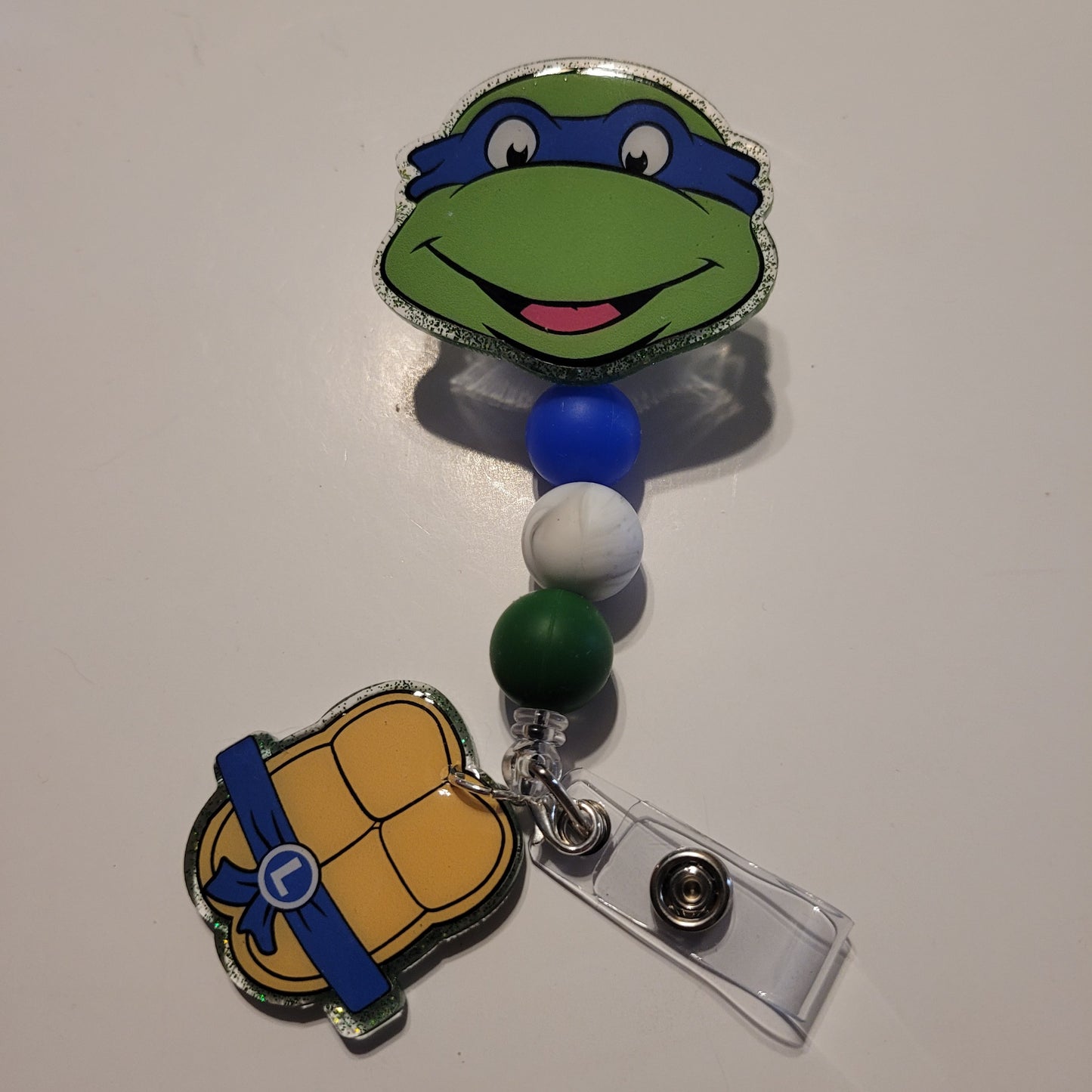 Retractable badge holder with turtle design on a white background