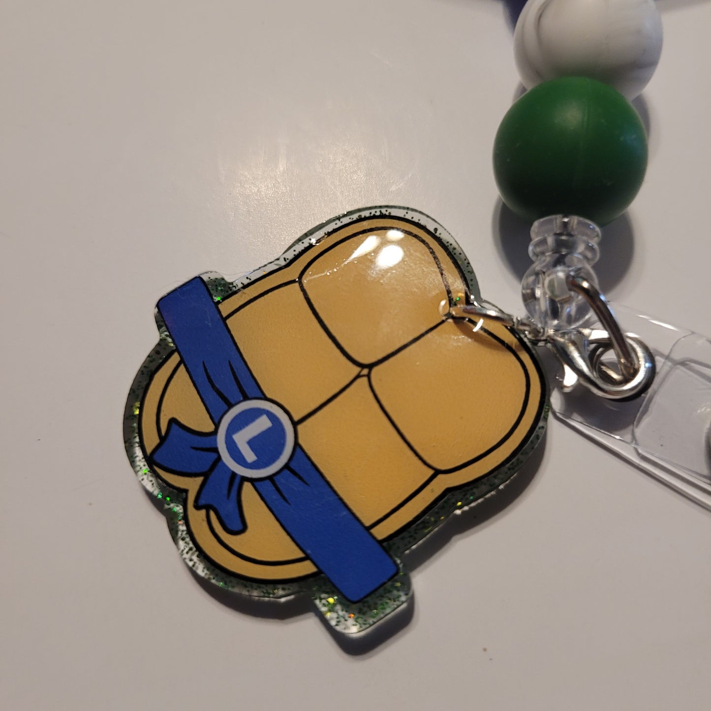 Tortoise shell badge holder with blue ribbon on a white background