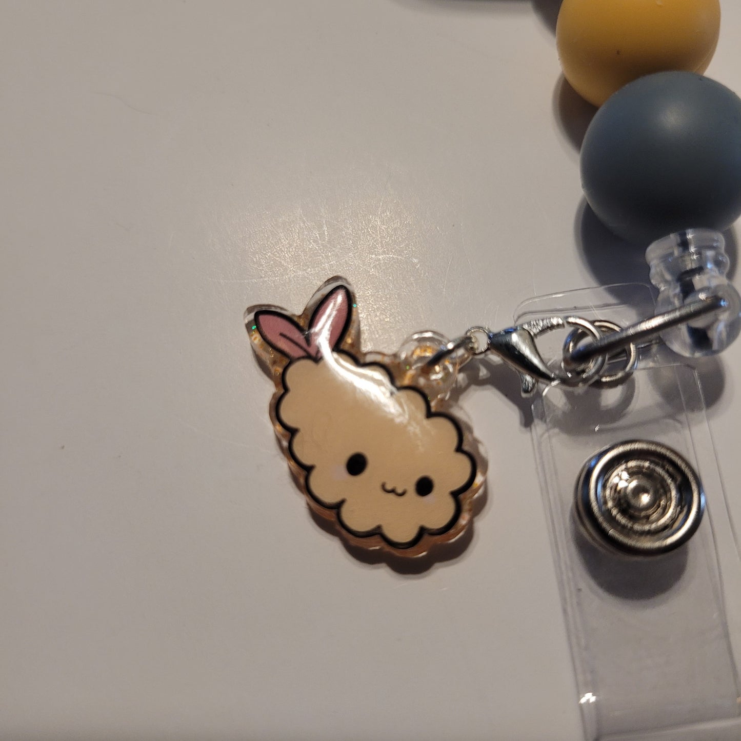 Kawaii-style cloud charm on a lanyard with a clear badge holder.