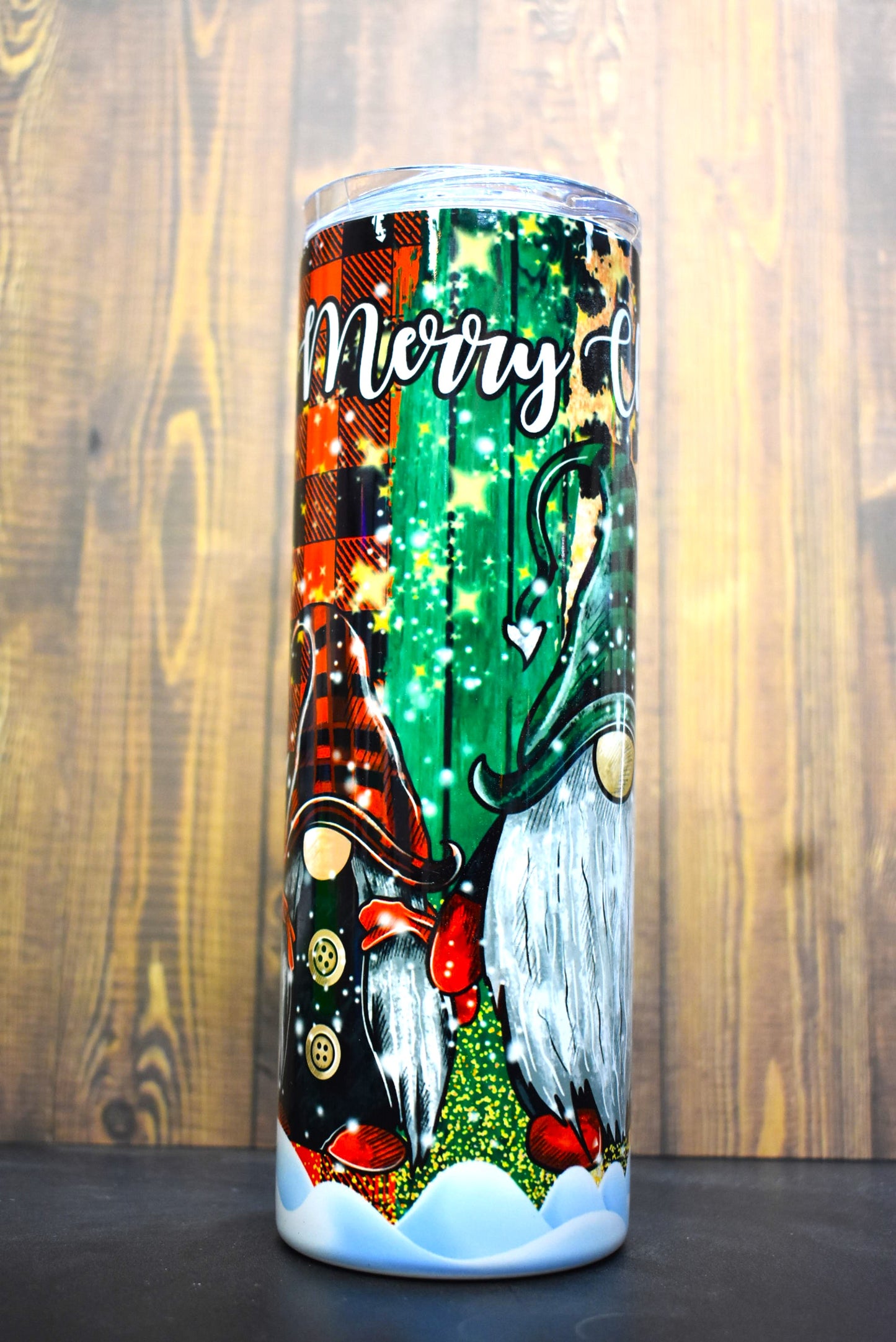 3 cute gnomes stand side by side bringing Christmas cheer. A beautiful background of various plaid, leopard prints glitters and more complete the look.