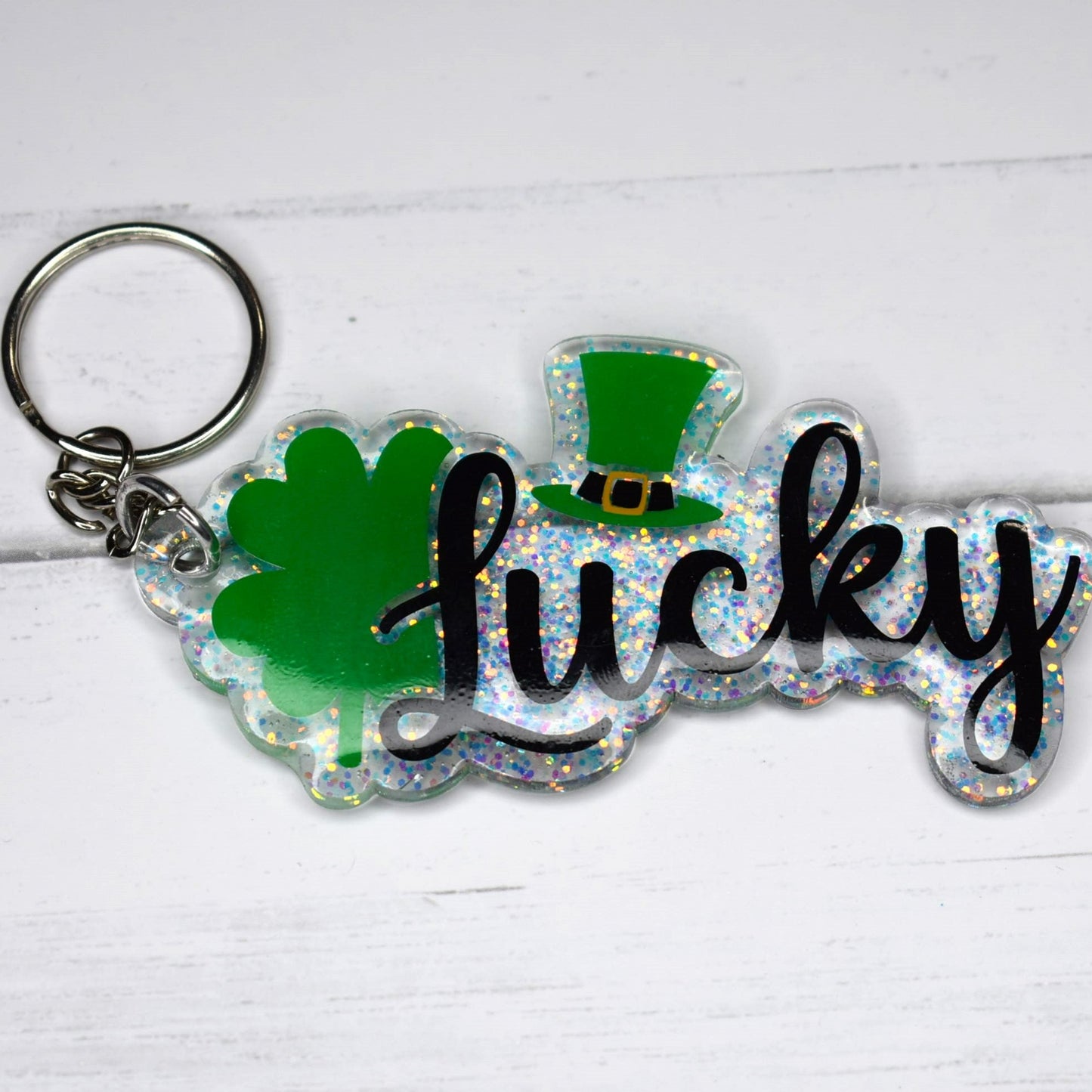 This keychain is made of acrylic resin and features a lucky Irish design. It comes in two options: a green glitter background or a sparkling clear glitter background. Show off your luck today!