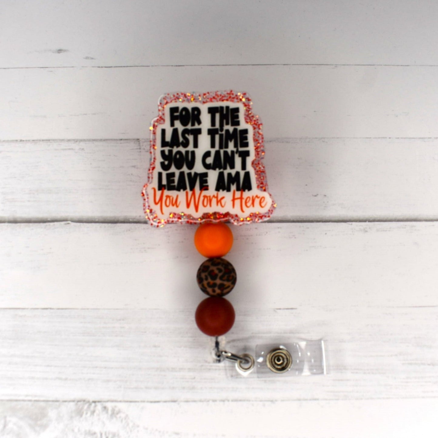 For the last time.... you can't leave AMA...You Work Here Funny words to use to try and ditch your job in any medical field...unless you have a note from your doctor....your staying at work! Red glitter base with color matching beads finish the look.