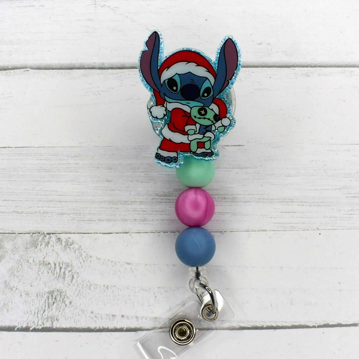 This badge reel features Experiment 626 enjoying Christmas. 4 different versions available. All badge reels feature a glitter base and color coordinated beads.