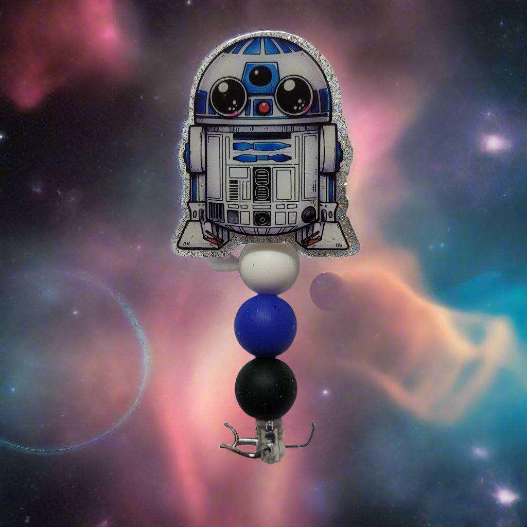 Unleash your inner power and wield this Droid to rescue the Universe! This little guy is dressed up in a shiny glitter back and adorned with 3 silicone beads.