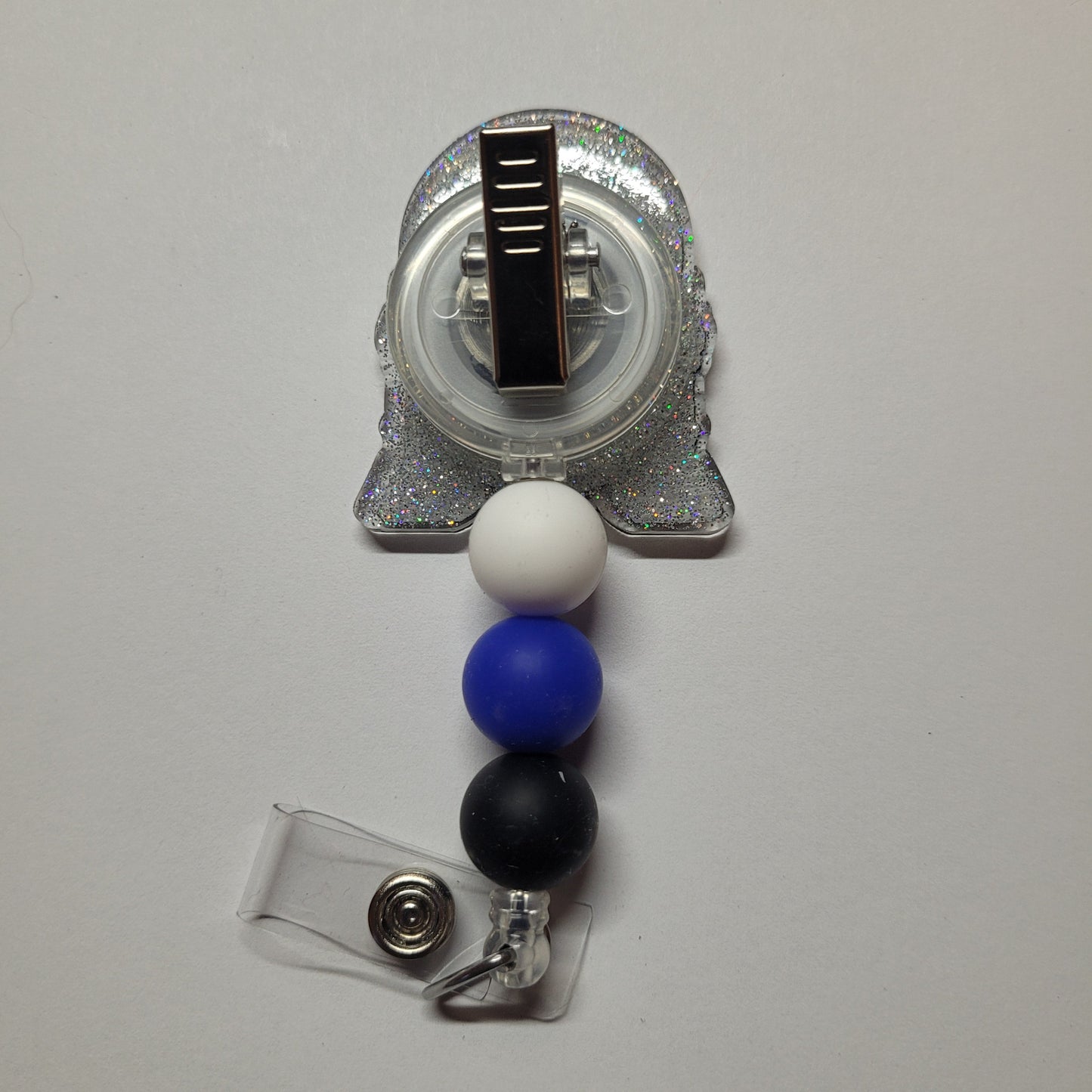 Unleash your inner power and wield this Droid to rescue the Universe! This little guy is dressed up in a shiny glitter back and adorned with 3 silicone beads.