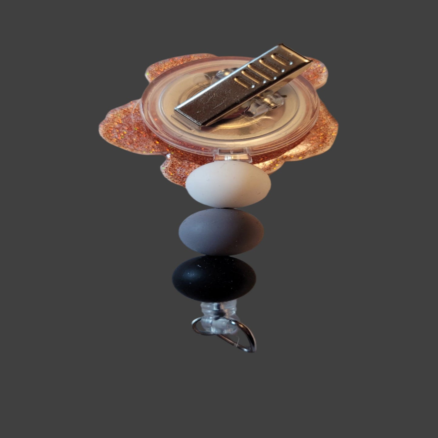 Upgrade your work ID game with our latest release of Medical Badge Reels - the EKG Leads Badge Reel! This unique piece features 5 leads on a white background with a pop of red glitter, complemented by 3 matching silicone beads for a complete look.