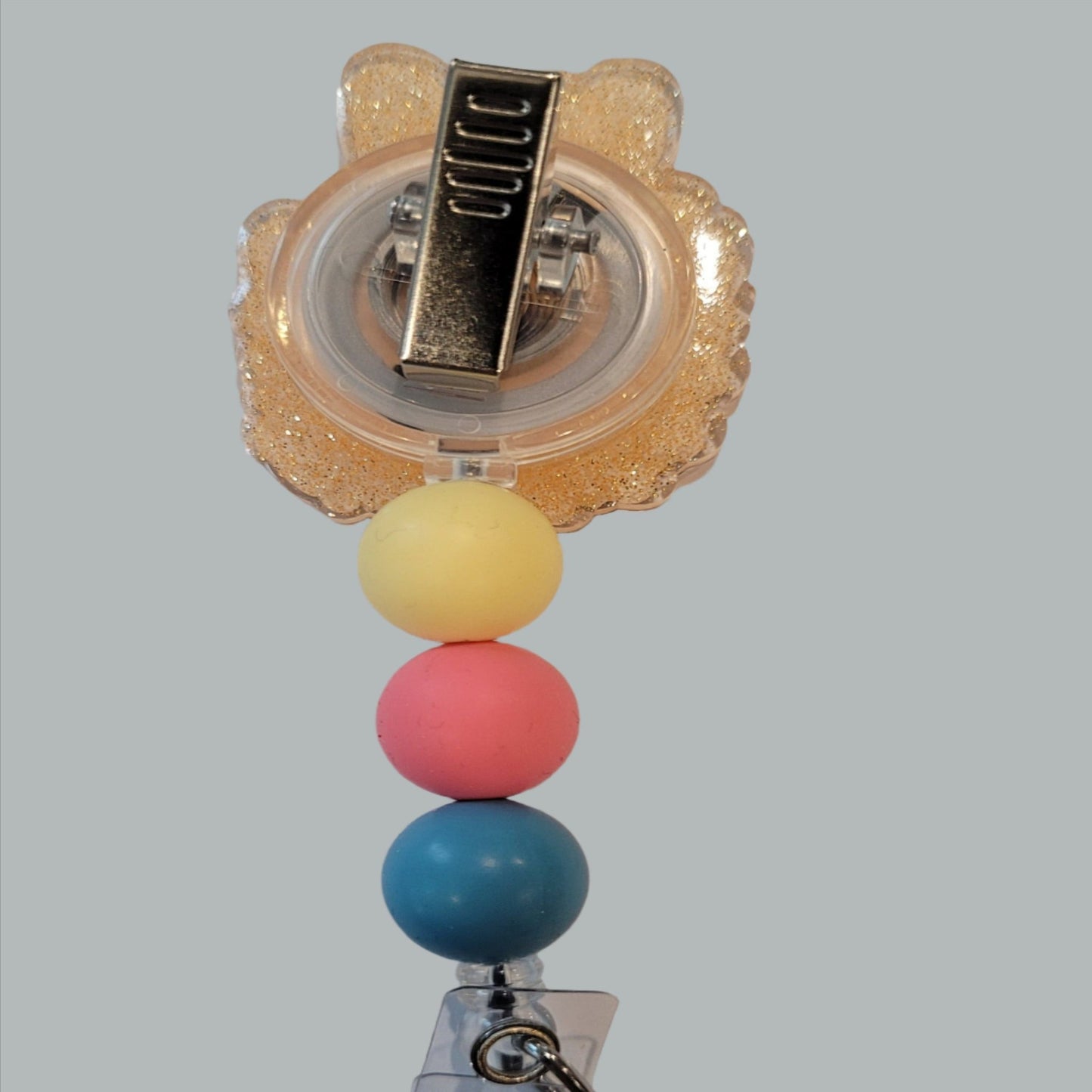 Unleash your inner whimsy with this delightful Badge Reel starring a charming little glasses wearing Bunny, Complete with a setting of wildflowers and a light orange glitter back. And don't forget the adorable trio of matching silicone beads for a dash of extra charm. Perfect for all animal enthusiasts!