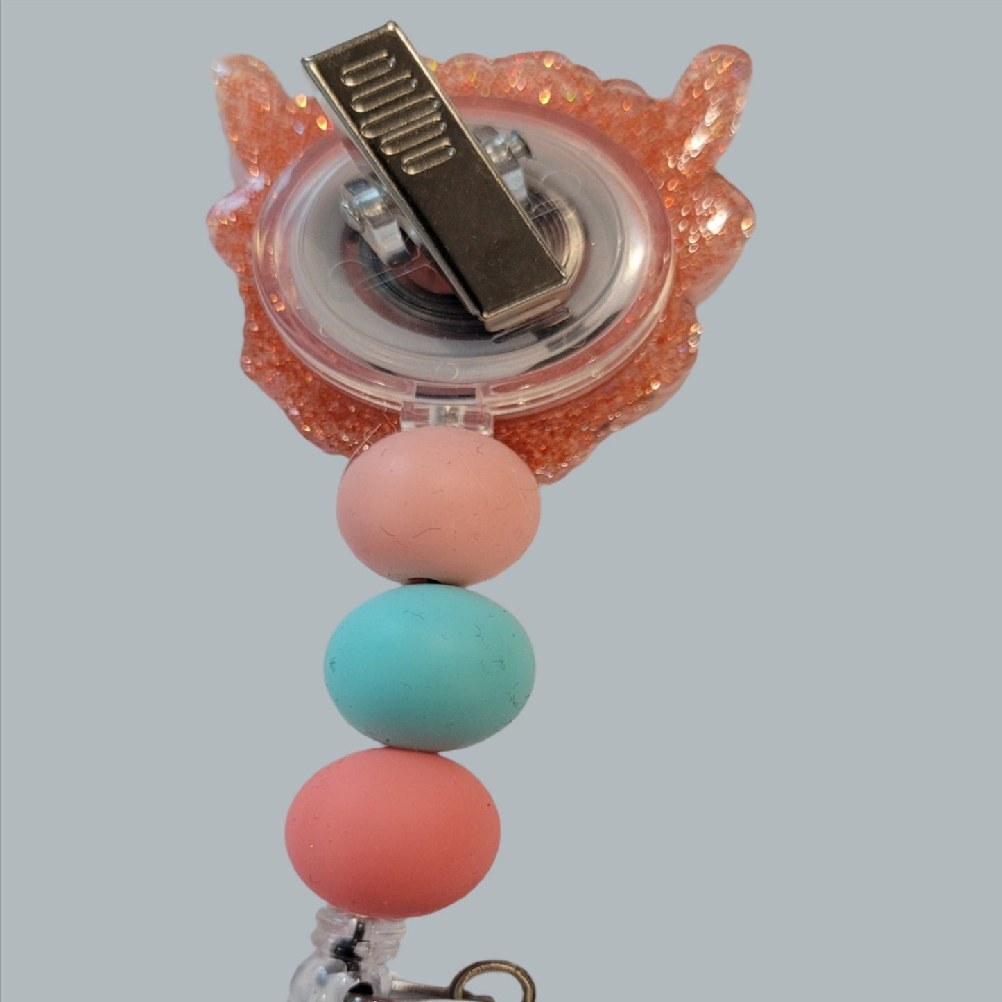The classic Highland Cow is here in a floral theme. Surrounded by flowers and wearing a floral crown this acrylic badge reel will put a smile on any animal lovers face. An orange glitter back and 3 silicone beads finish the look.