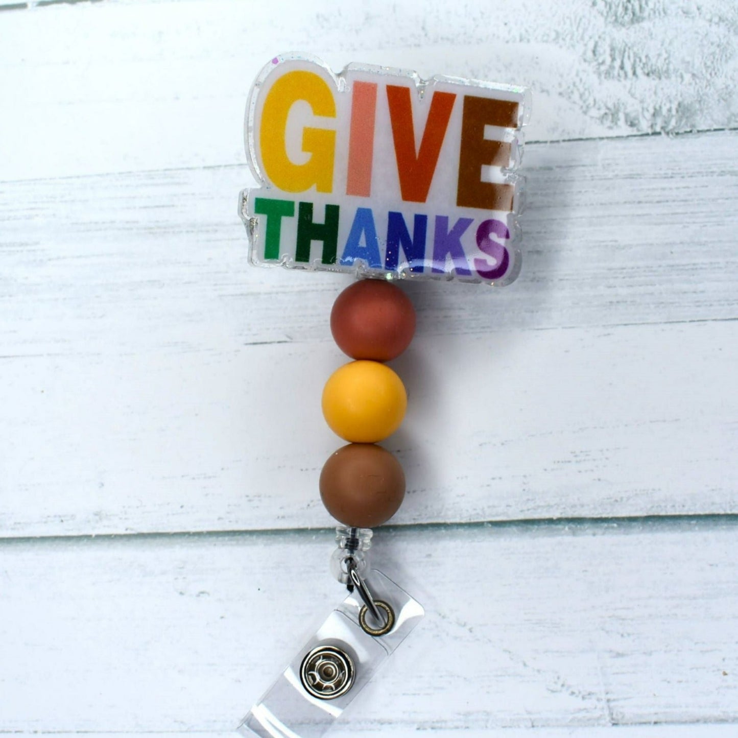 This acrylic badge reel with neutral colored silicone beads embodies the spirit of Thanksgiving. Together, they create a cohesive aesthetic that is eye-catching and stylish.