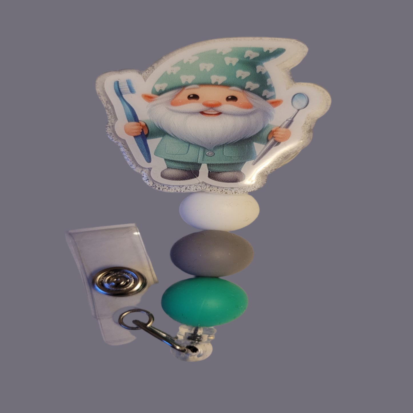 This playful Gnome Dentist knows if you're brushing and flossing, complete with a toothbrush and dental inspection mirror, plus a glittery white back and 3 matching silicone beads!