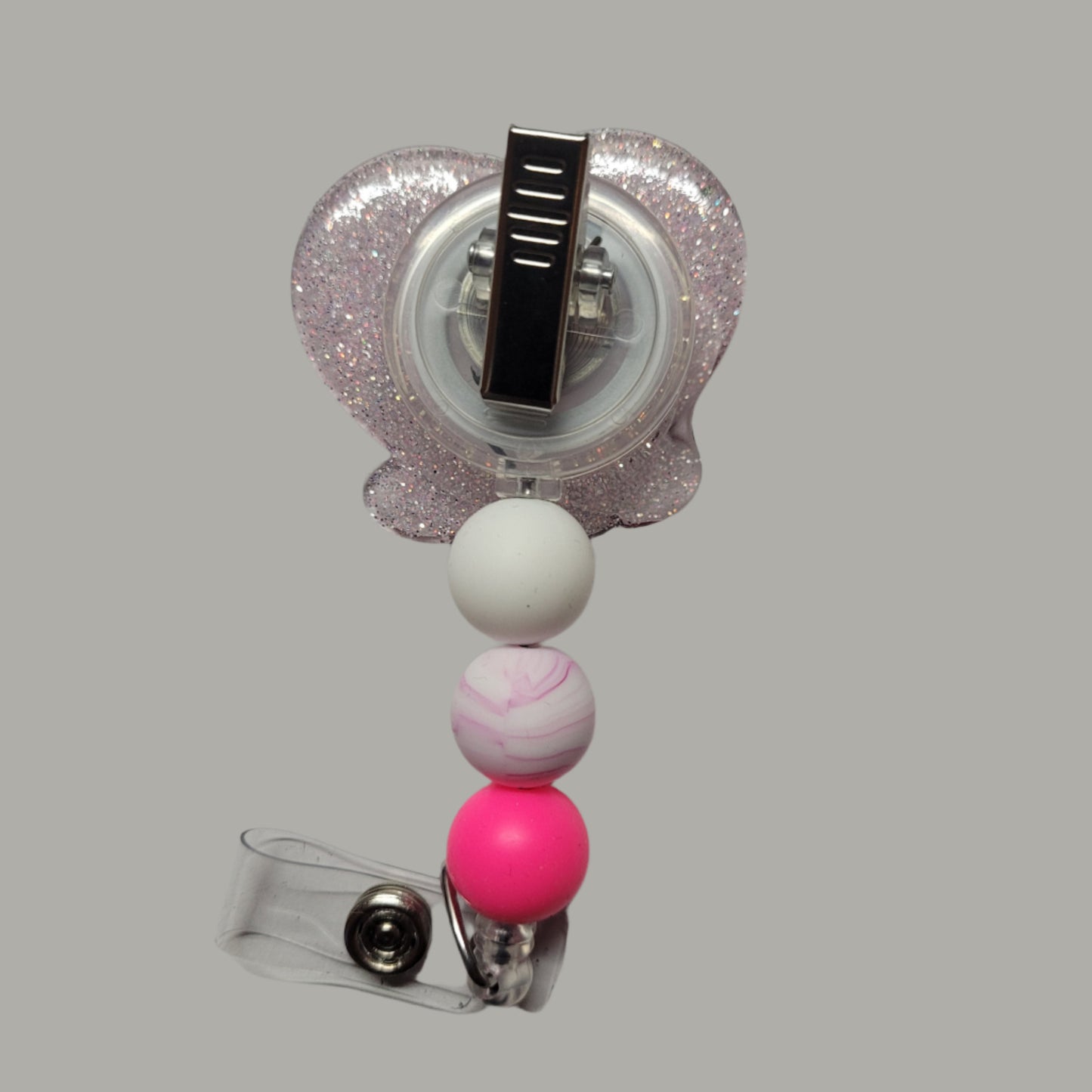 By popular demand we bring you a new series of Kitty Badge Reels. Here is our Love Kitty sporting a Pink jacket with a heart and her flashing you peace signs and a pink ribbon in her hair. Light Pink glitter on the back and 3 silicone beads finish the look.