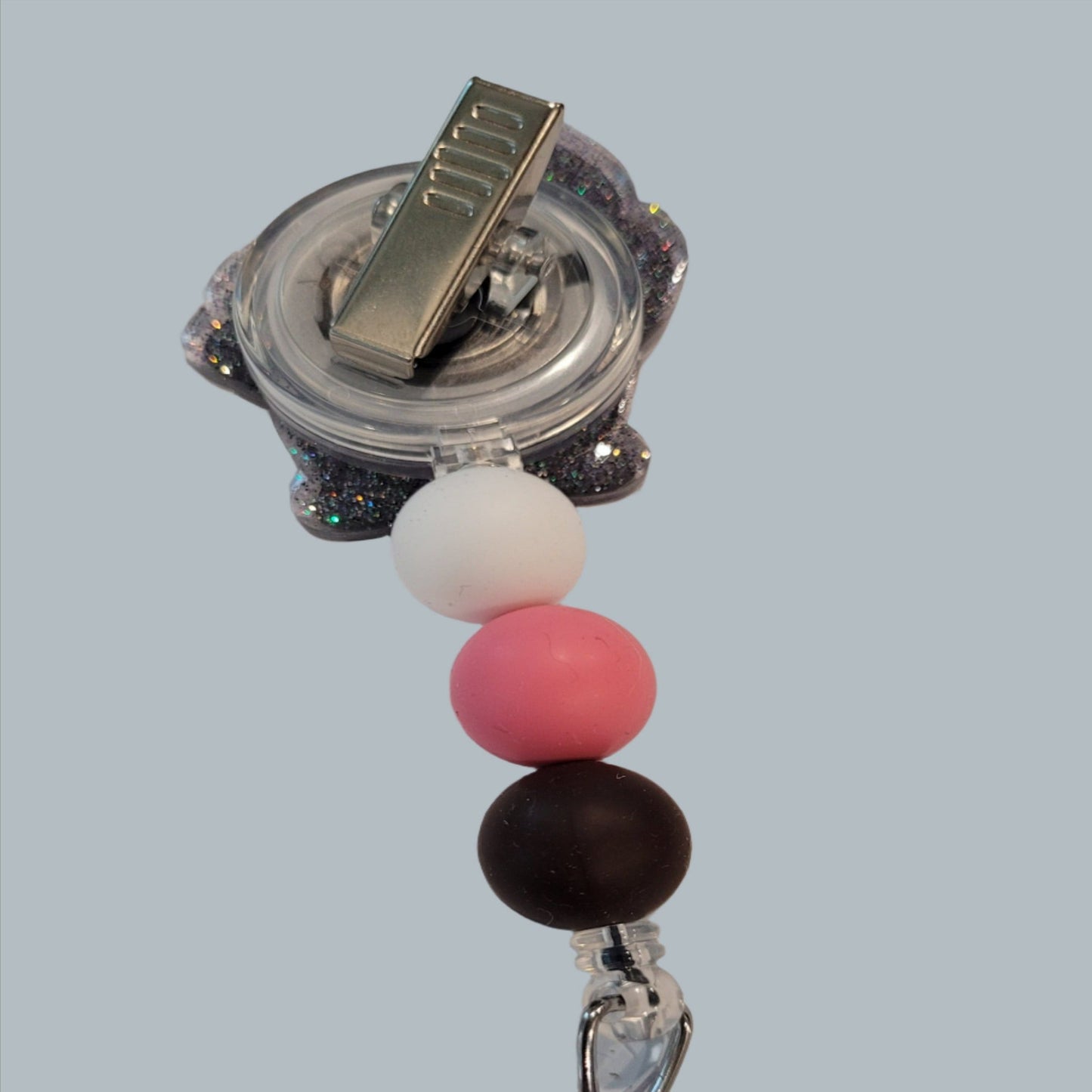 Looking for a charming badge reel? Well, look no further because we've got our Cute Pig here! With a glittery gray back and 3 matching silicone beads, it's perfect for all the animal lovers out there.