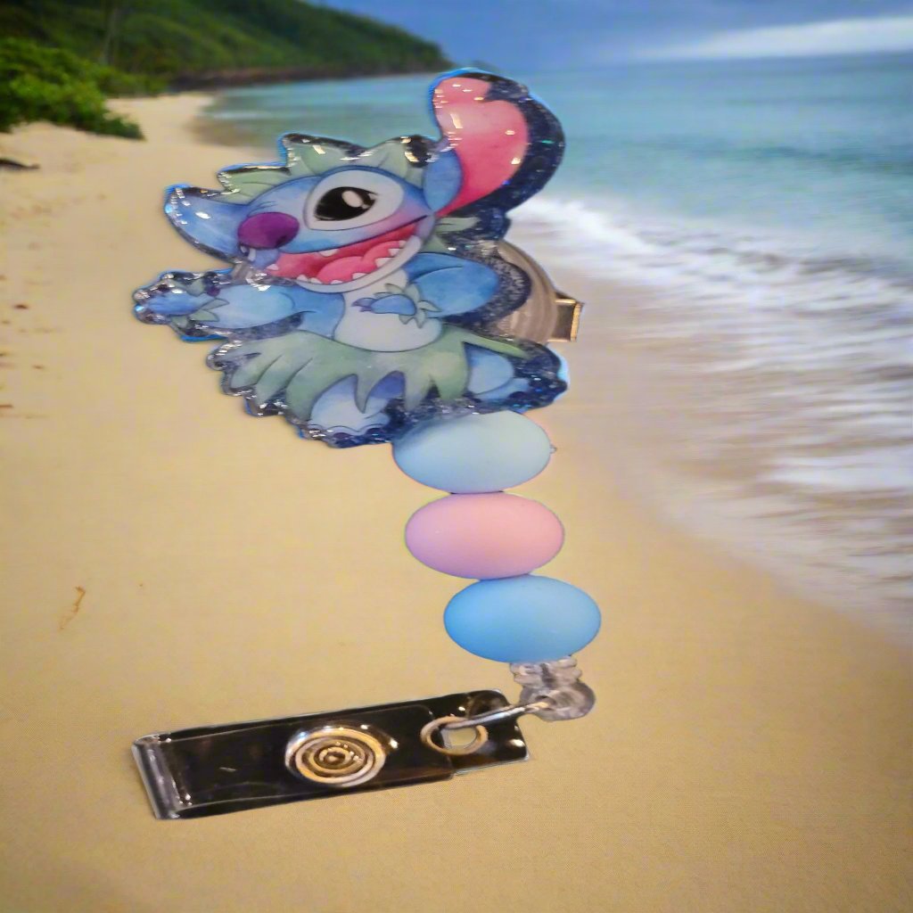 Stitch dancing a Hula in all his cuteness. This badge reel has a shiny glitter base and is finished with 3 color coordinated silicone beads.