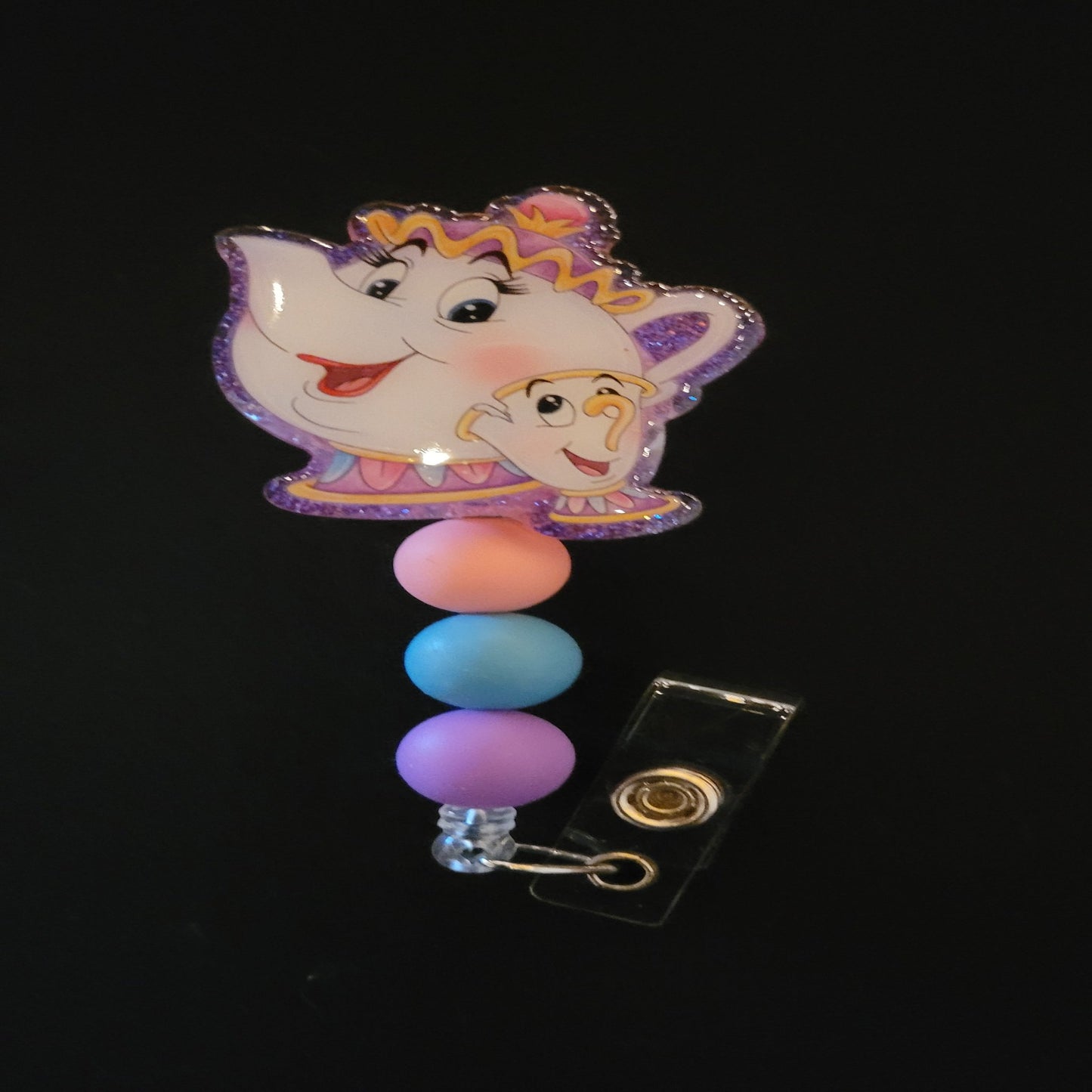 Mrs Teapot is here to heat things up. This badge reel has a shiny glitter base and is finished with 3 color coordinated beads.