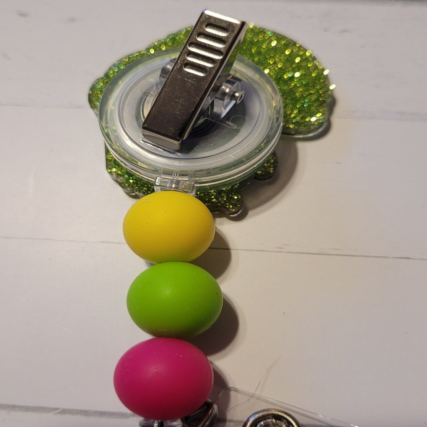 Unlock the ultimate summer vibes with this Badge Reel we call Penguin Pop. This stylish acrylic badge reel features a cool penguin wearing sunglasses enjoying a popsicle and adorned with vibrant silicone beads, giving it a classic and lively look.
