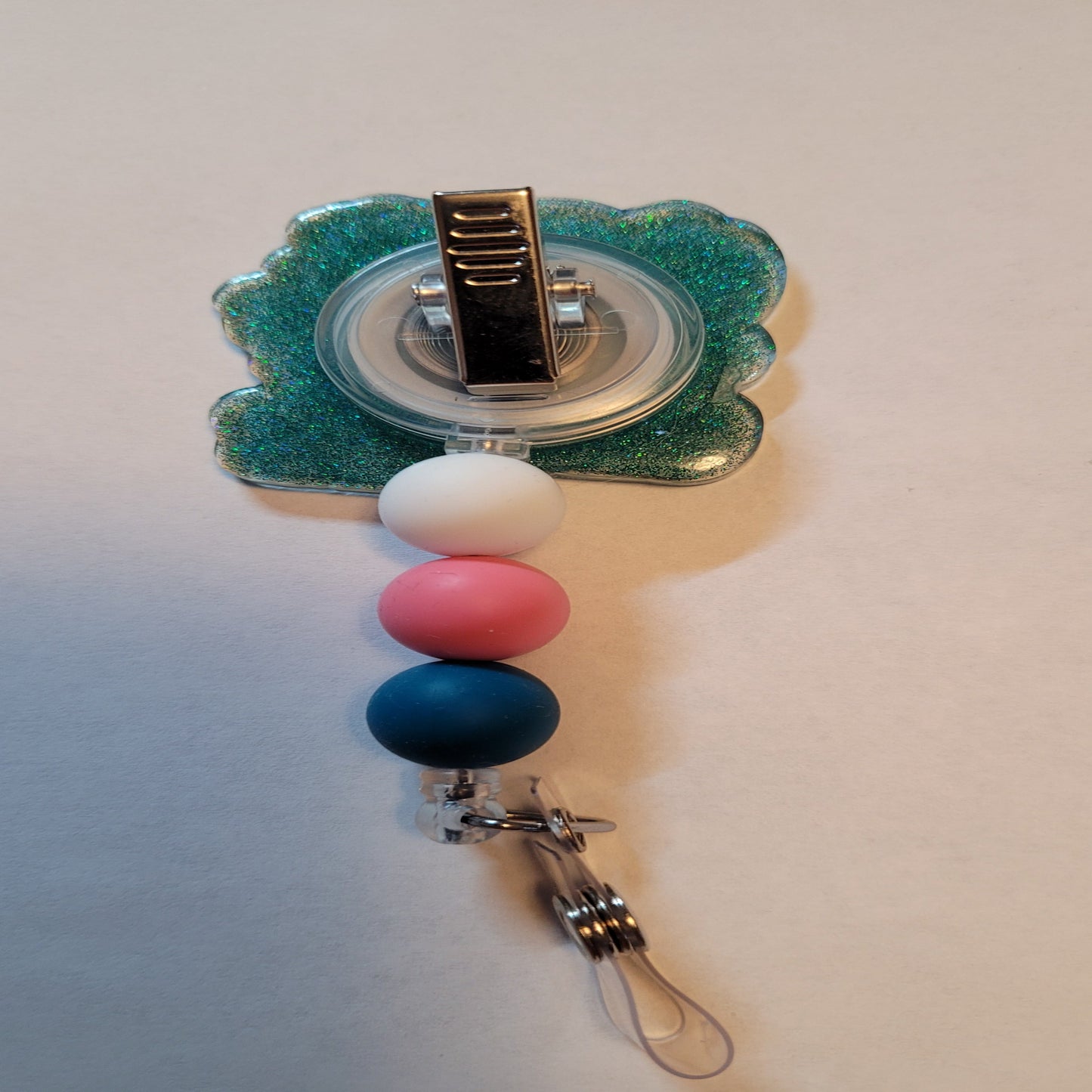 New to our Medical Field lineup is a tribute to all the women in any medical area. As quoted from Proverbs 31:13 "She Works Willingly With Her Hands". This badge reel fully embraces that with various tools of the trades on the front and a Light Blue/green glitter base and matching beads for a polished finish.