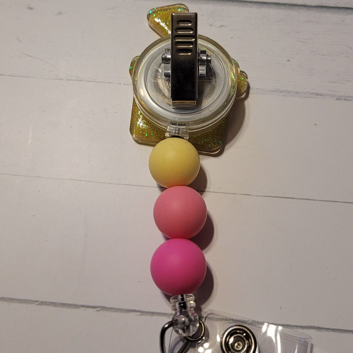 Heading to the beach? Grab your shovel & pail for some sandy fun! With a cheerful pink pail adorned with a bright yellow star fish and color-coordinated silicone beads to top it off.