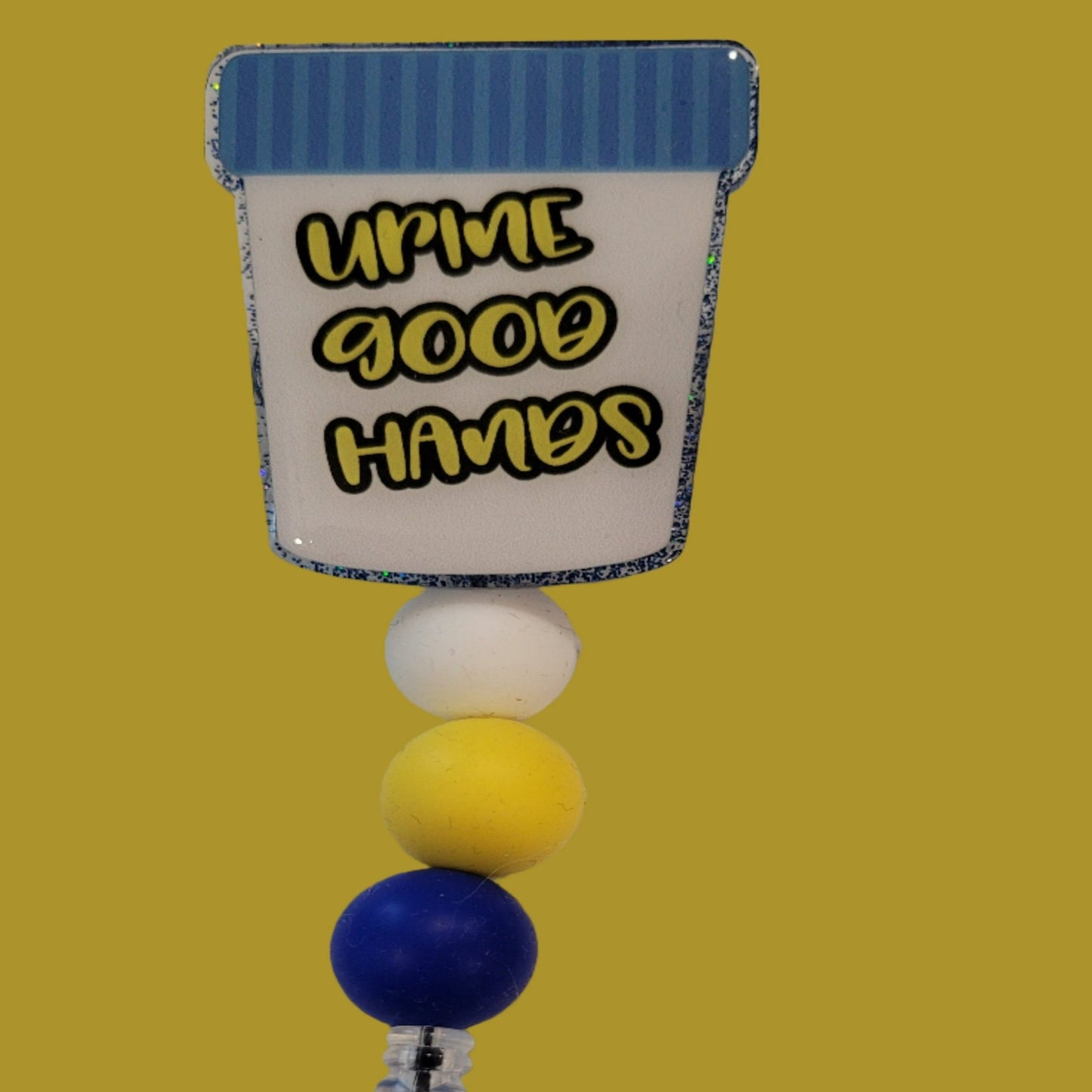 Part of our latest collection of Medical Badge Reels available now, we will need this filled for the Urine Good Hands Badge Reel. Featuring a collection cop and a light blue glitter base adorned with coordinating beads, this Badge Reel is sure to catch....well we will leave that alone.