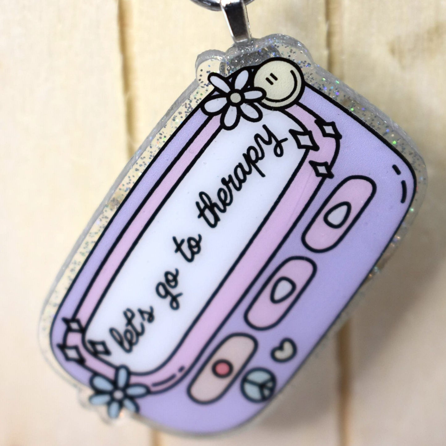 Keychain Lets Go To Therapy is crafted from durable acrylic resin and comes in pink or purple. Perfect for those in need of some therapy on the go.