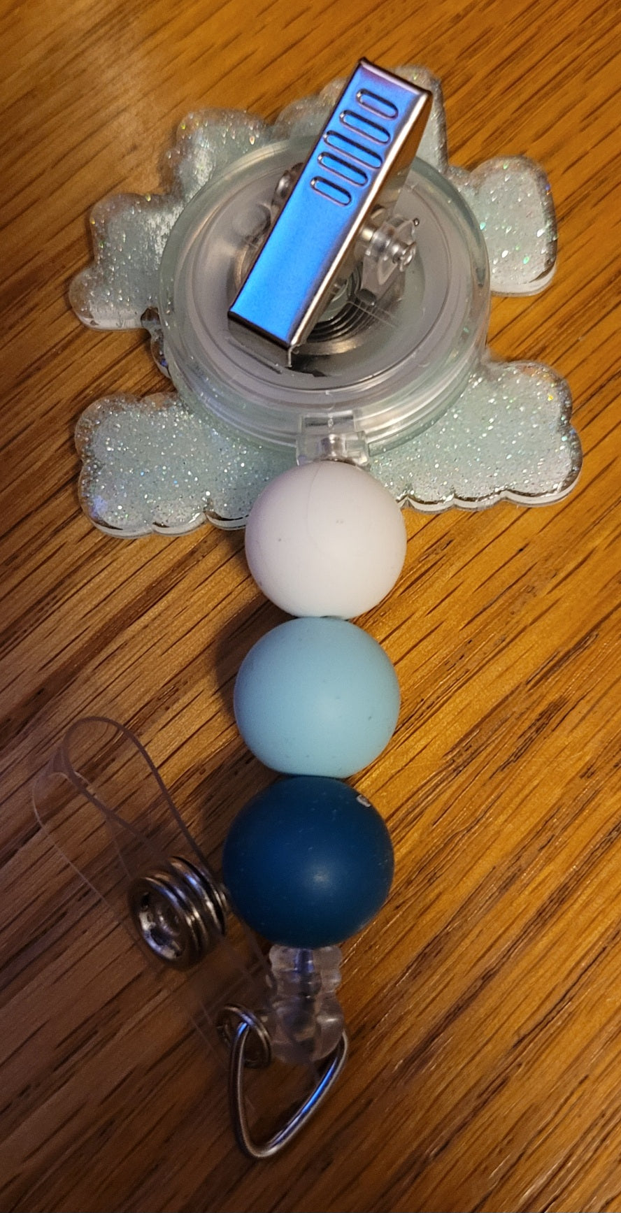 Now Part of our Medical Badge Reels collection, we have available, Save Lives. With the phrase It's A Beautiful Day To Save Lives on the front with a light teal glitter base on the back adorned with 3 coordinating silicone beads. What a great mindset!