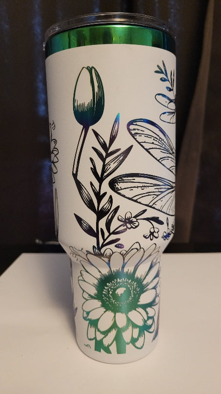 Introducing the latest addition to our collection: the 40 oz Gold Plated Tumbler featuring laser-etched full-wrap from another on a sleek white background. Features 2 dragonflies amongst various flowers
