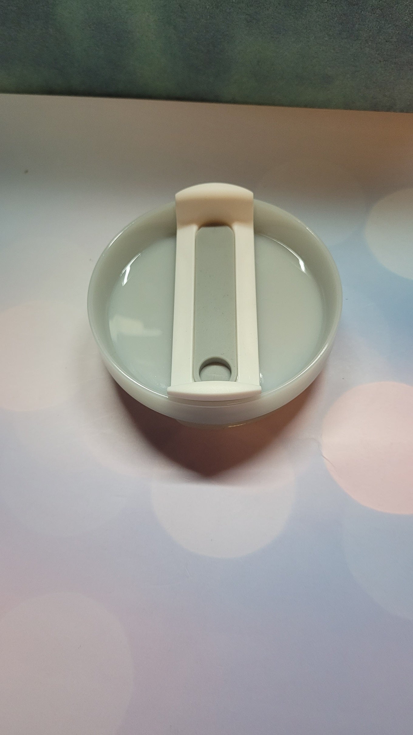 Small round container with a lid on a colorful surface