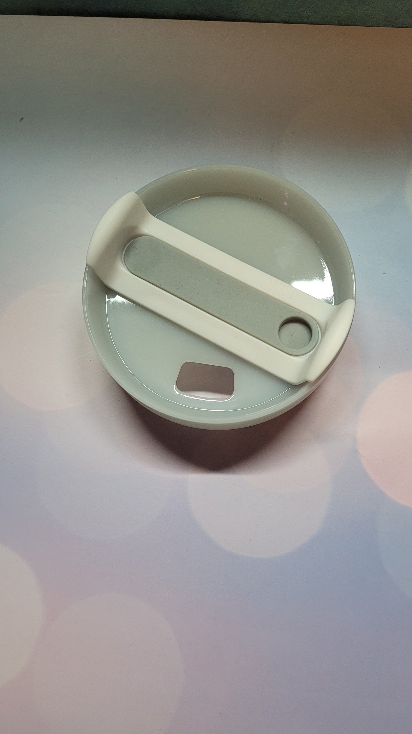 Round container with a white lid on a light gray background