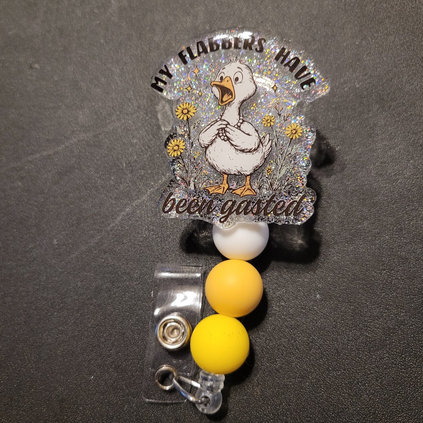 Badge holder with cartoon duck and text on a dark background