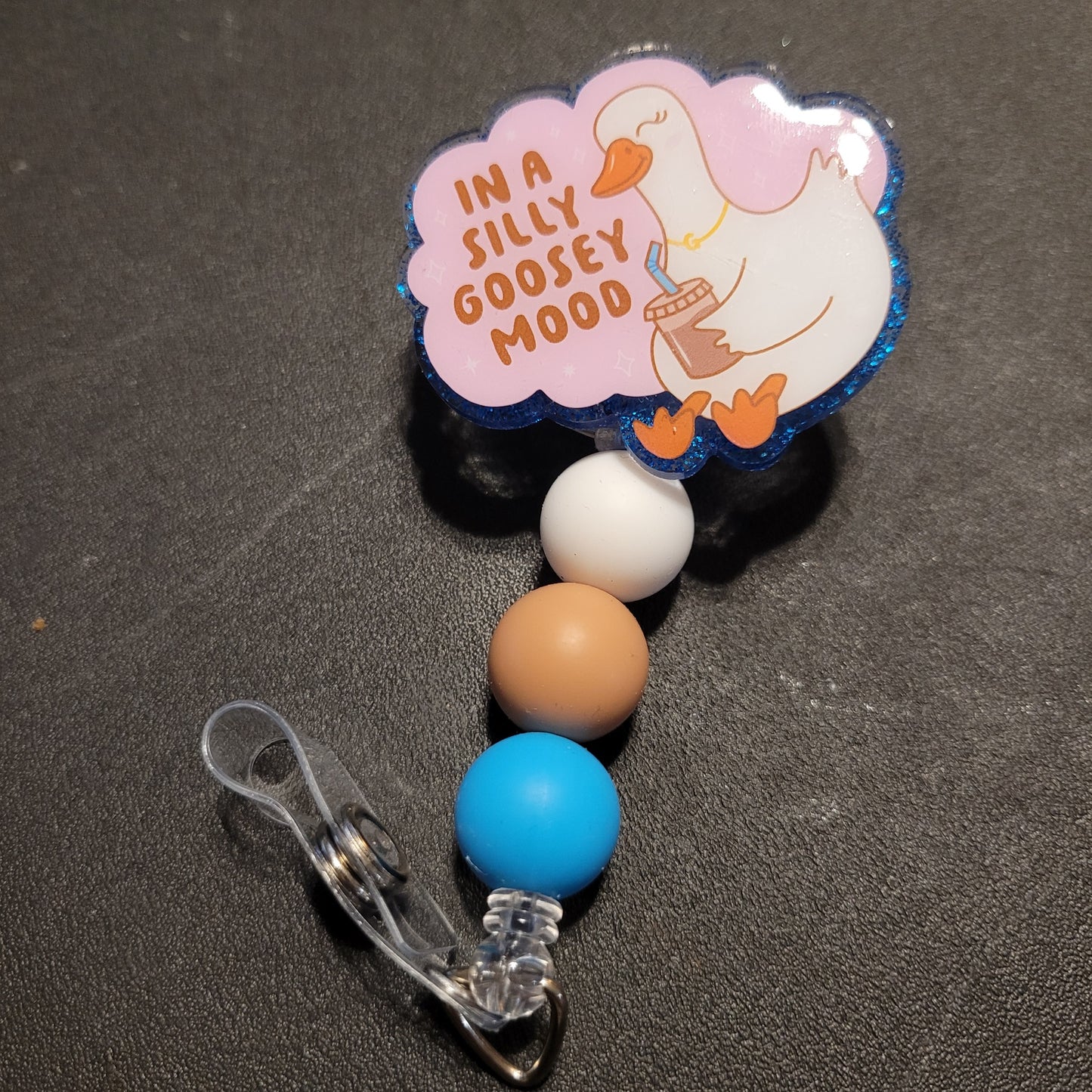 Retractable badge holder with cartoon duck and 'In a Silly Goosey Mood' text on a dark background
