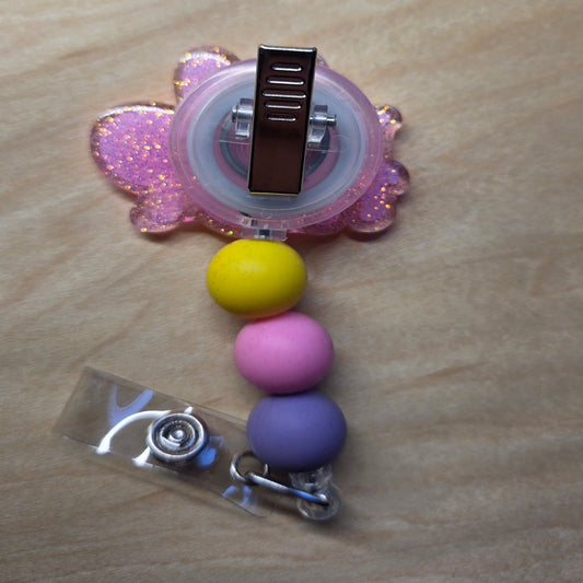 Colorful badge holder with beads on a wooden surface