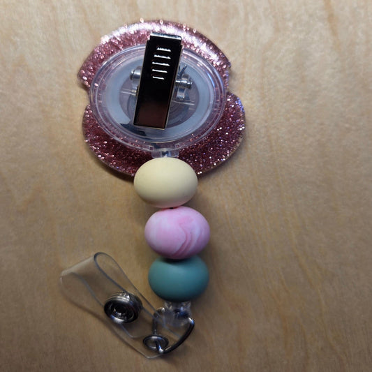 Colorful beaded badge holder with a clip on a beige background