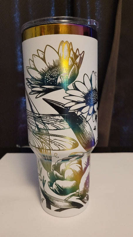 Introducing the latest addition to our collection: the 40 oz Gold Plated Tumbler featuring laser-etched full-wrap from another on a sleek white background. Features 2 dragonflies amongst various flowers