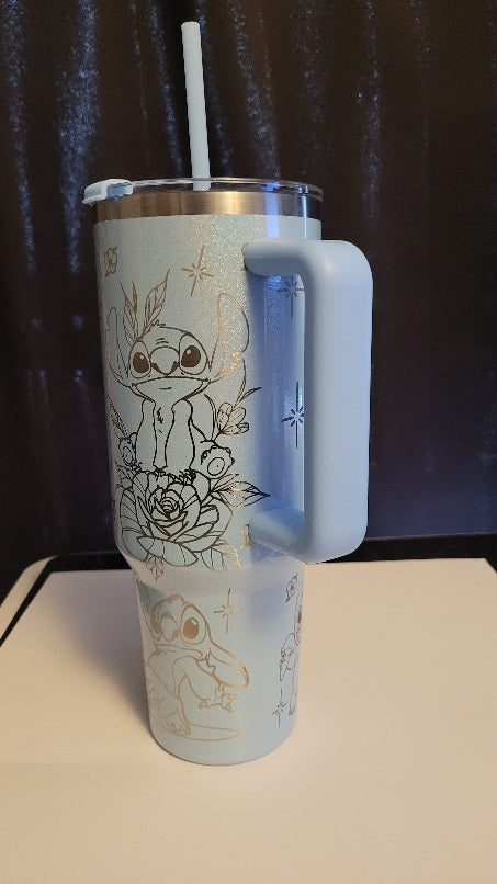 Tumbler with handle and straw featuring illustrations on a dark background