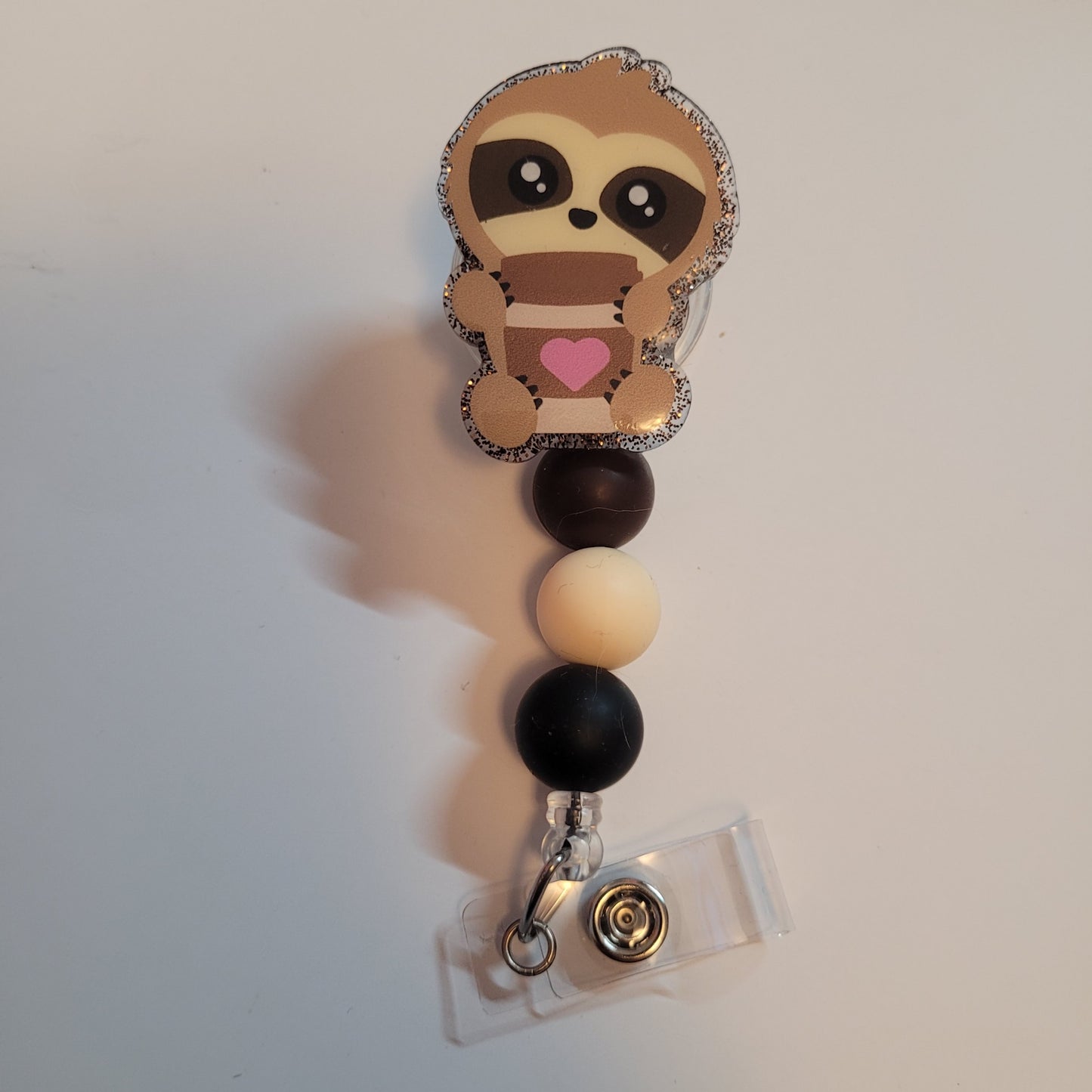 Sloth-themed badge holder with colorful beads on a white background