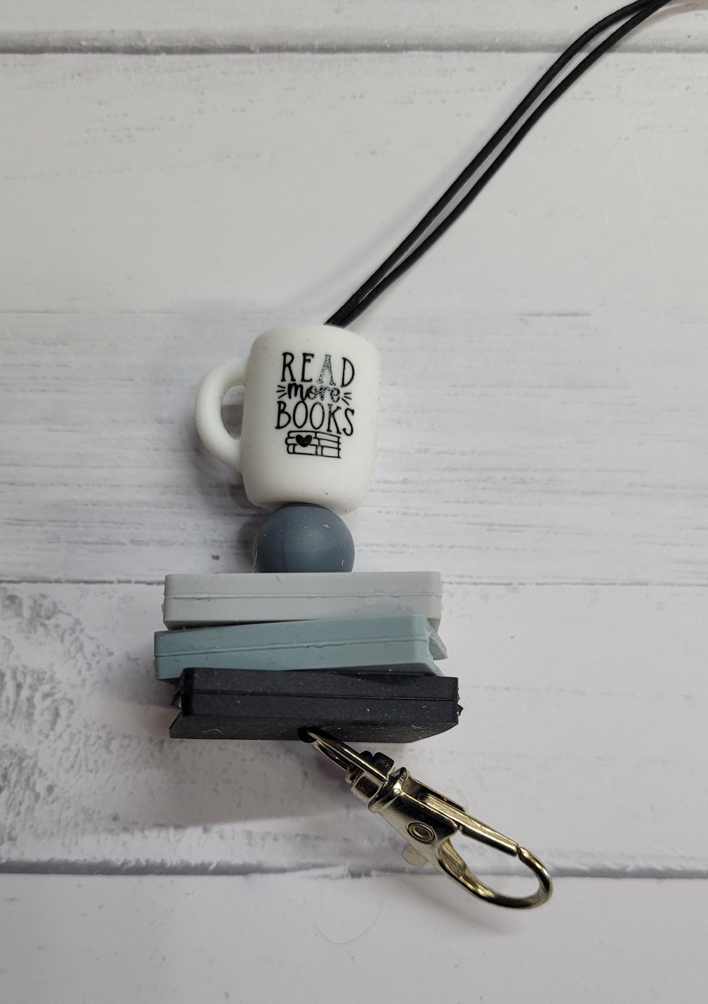 Need a custom Freshie Hanger? Here is a silicone beaded hanger we like to call Read More Books. All silicone bead construction with a sturdy clip to hang your Freshie from. Features a White Coffee Cup with the phrase Read Mor Books main bead and color coordinating beads to finish it off. Attaches quickly to any one of our many Freshies so you can easily hang it from your rear view mirror.