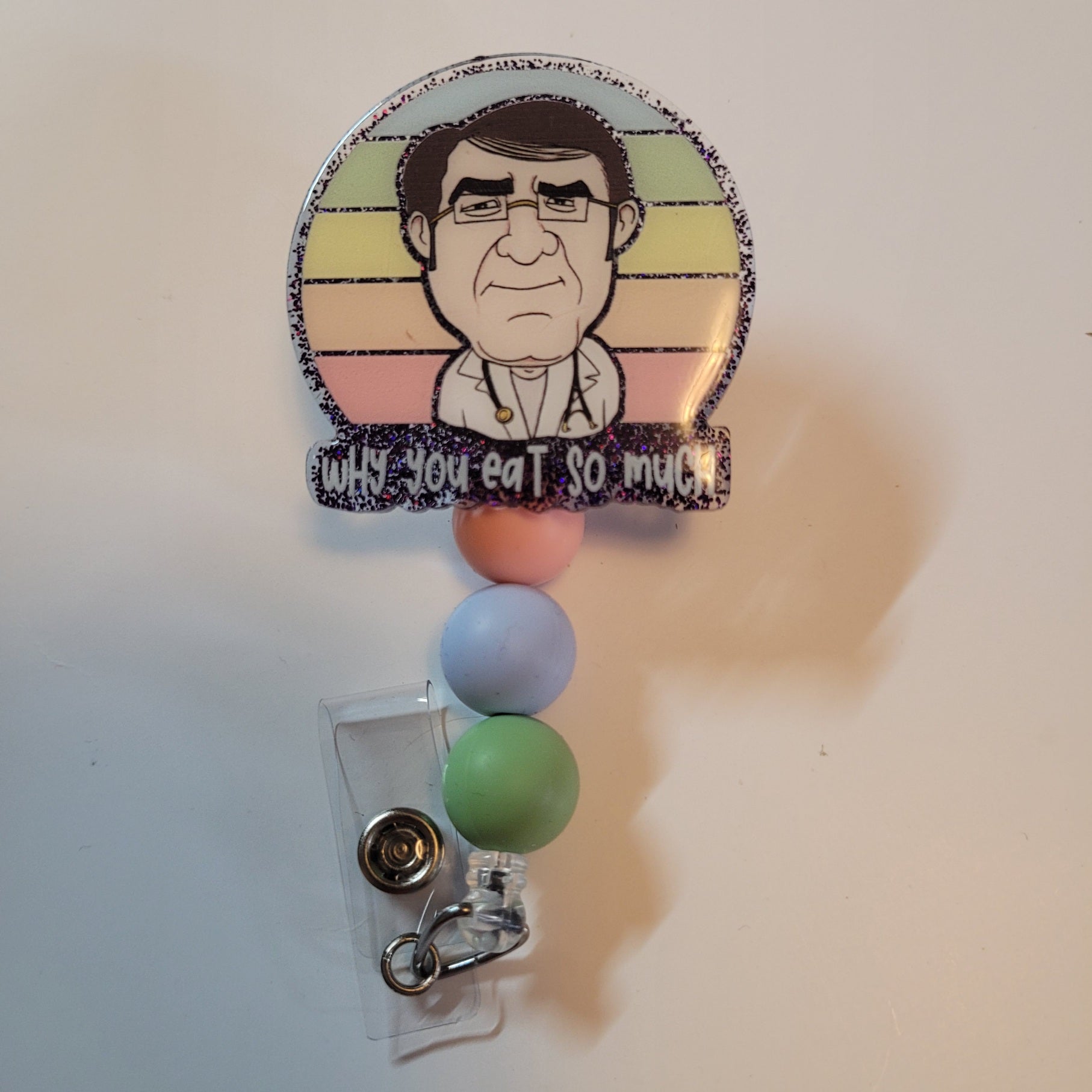 Badge holder with cartoon character and colorful beads on a plain background